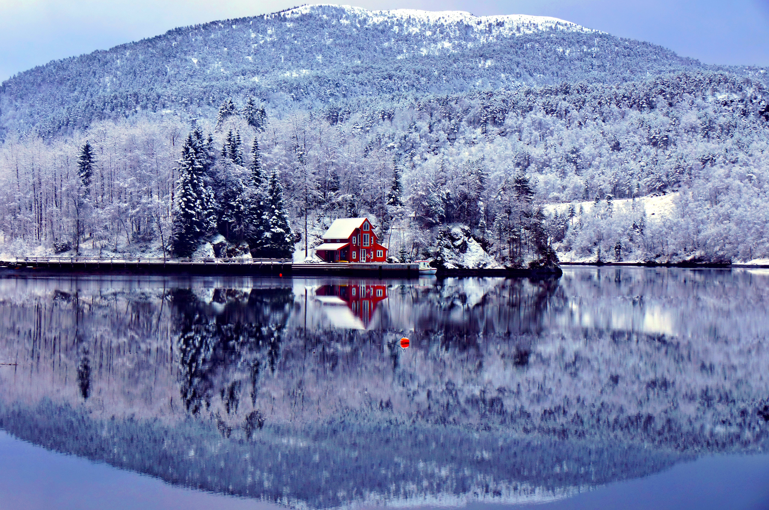 Free photo A red house on the lakeshore in the snowy fall