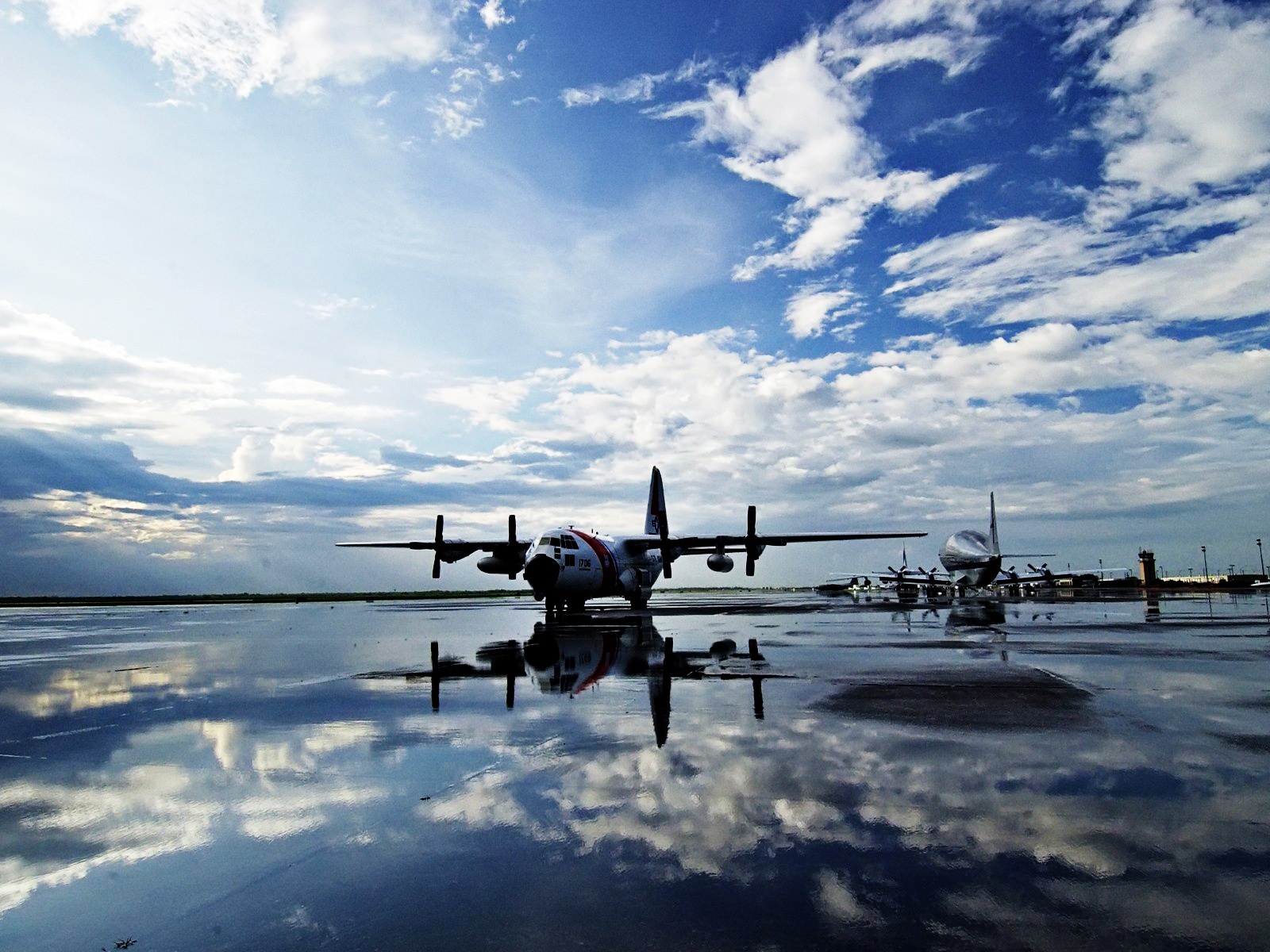 Free photo Airplanes reflect on the runway after a rainstorm