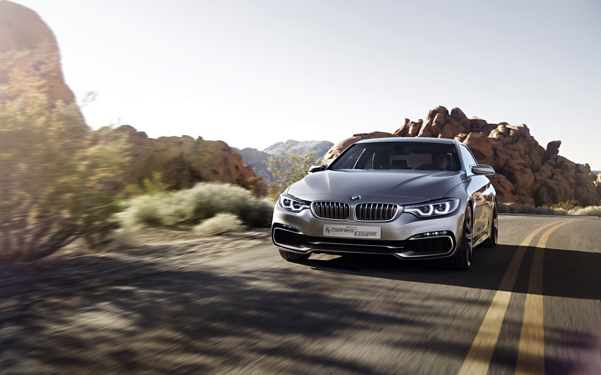 Free photo A Bmw 4 coupe driving down a country road.