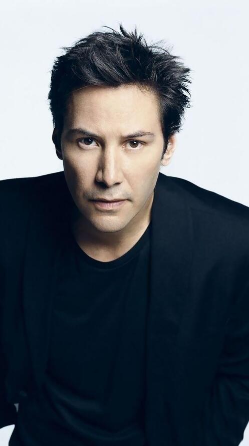 Бесплатное фото Киану Ривз в черном костюме на белом фоне