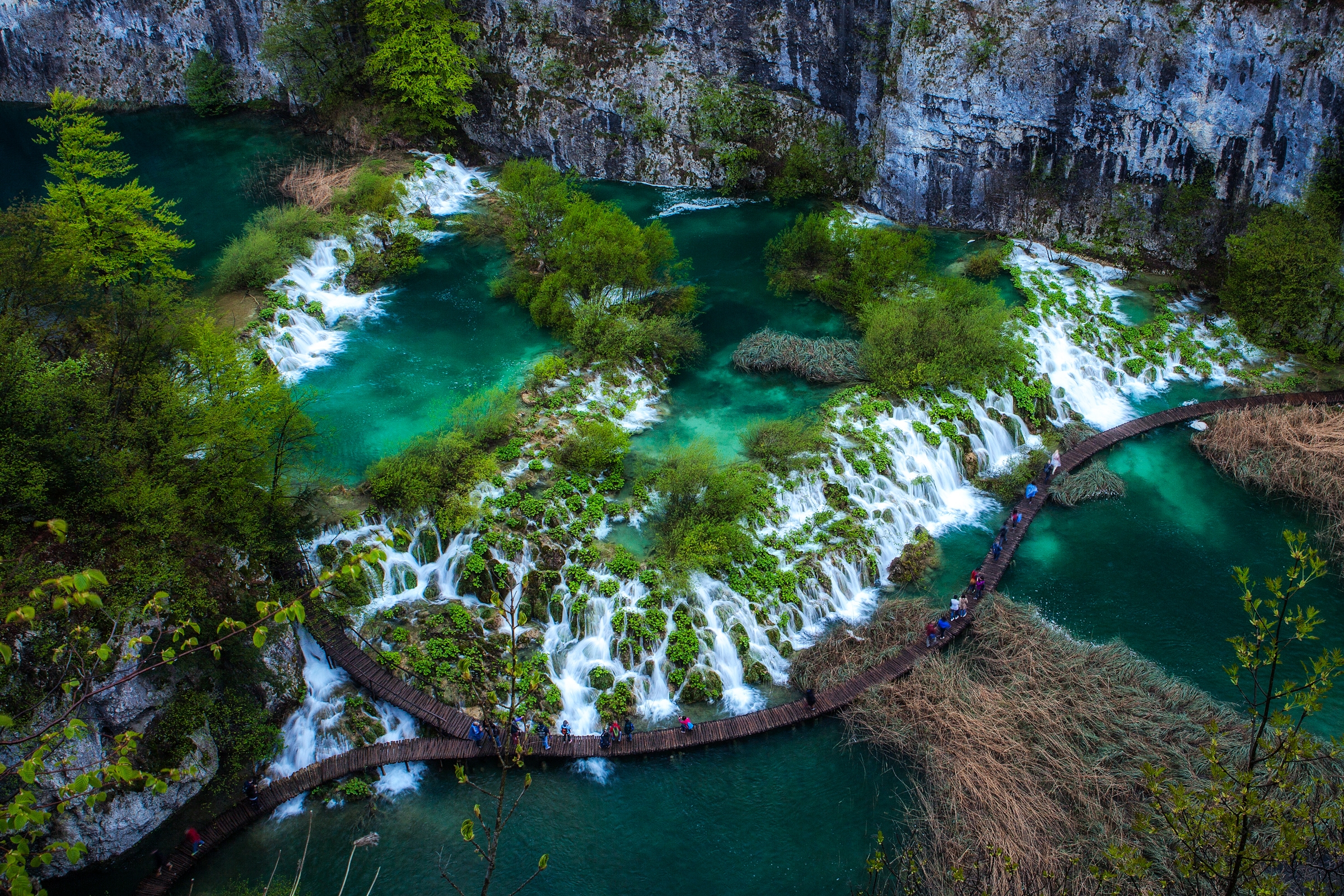 Free photo Tourists walk on a bridge in Plitvice Lakes National Park