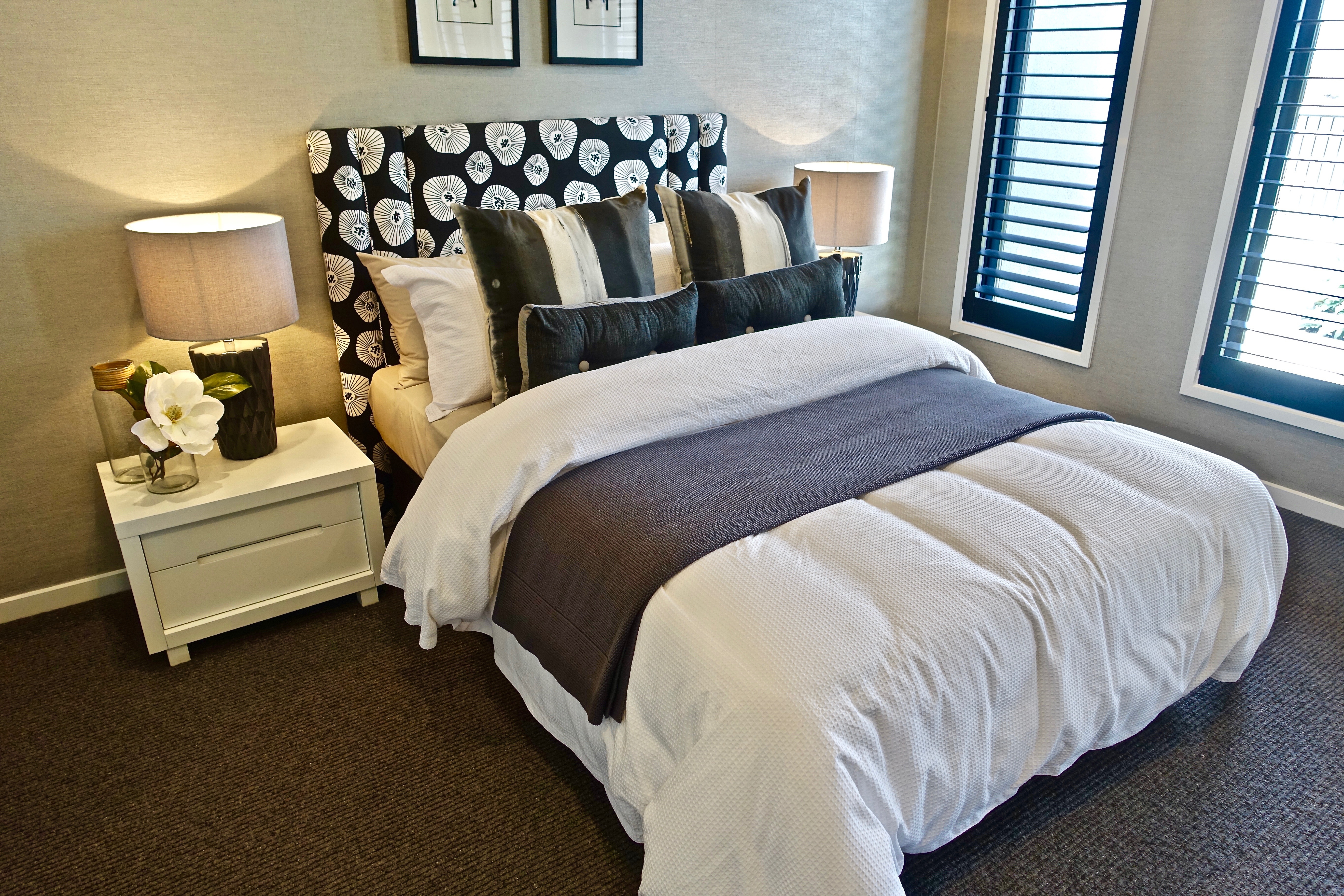 Спальня с большой кроватью, оформленная в спокойных тонах с элементами декора.