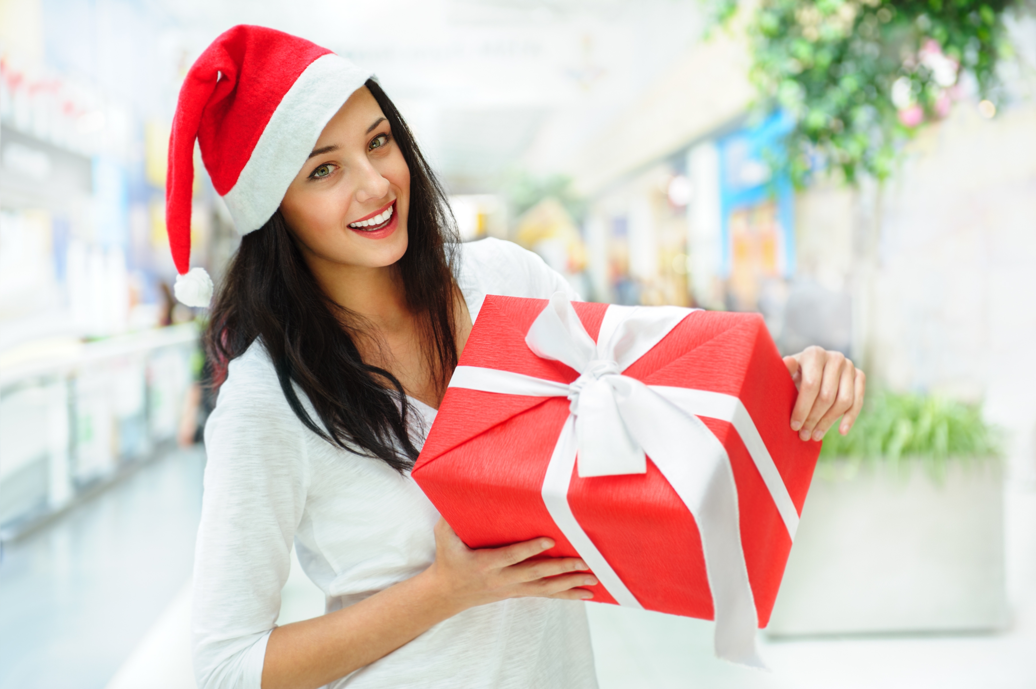 Free photo A girl with a gift in a New Year`s hat