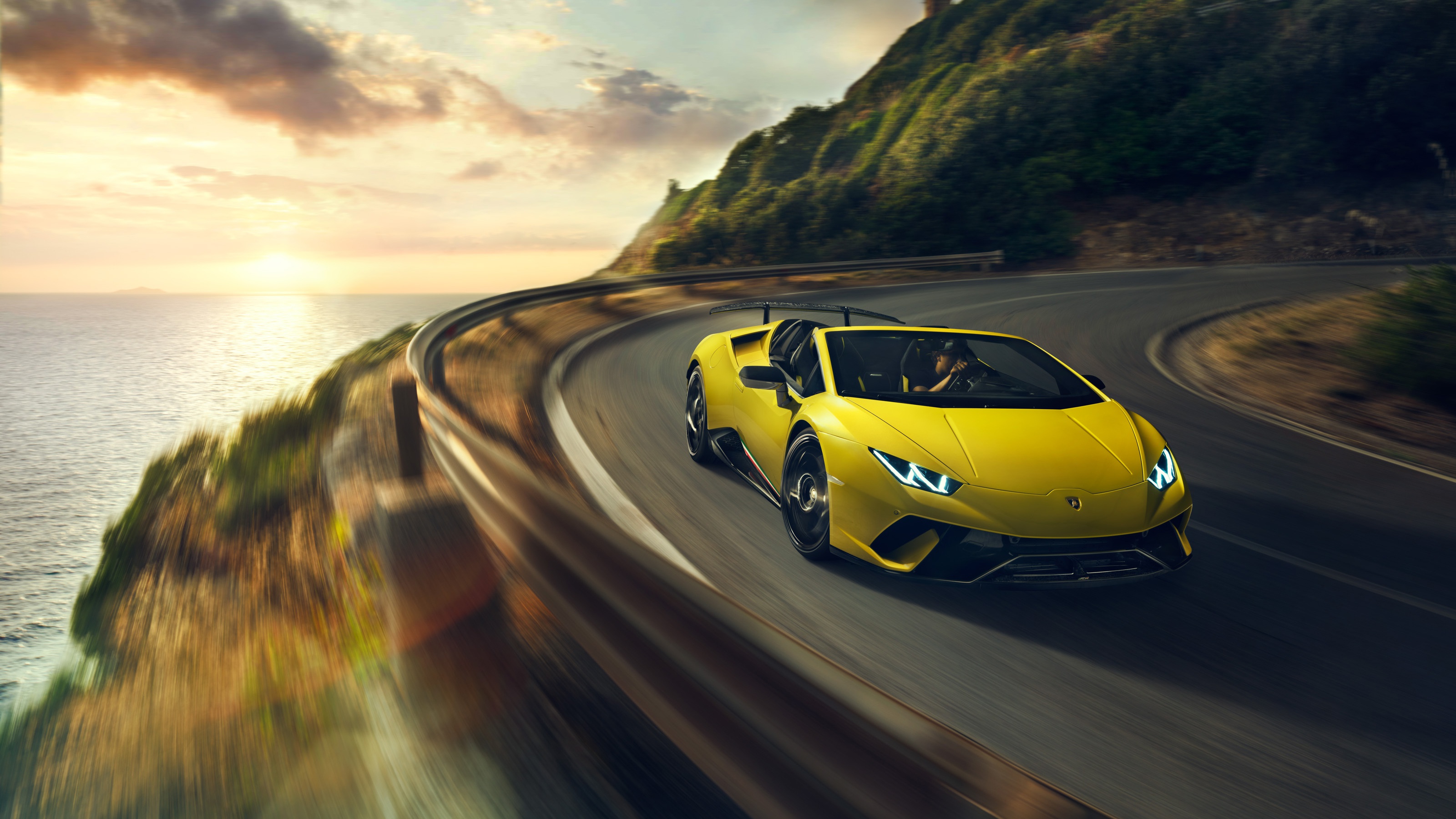 Yellow Lamborghini Huracan racing down a country road