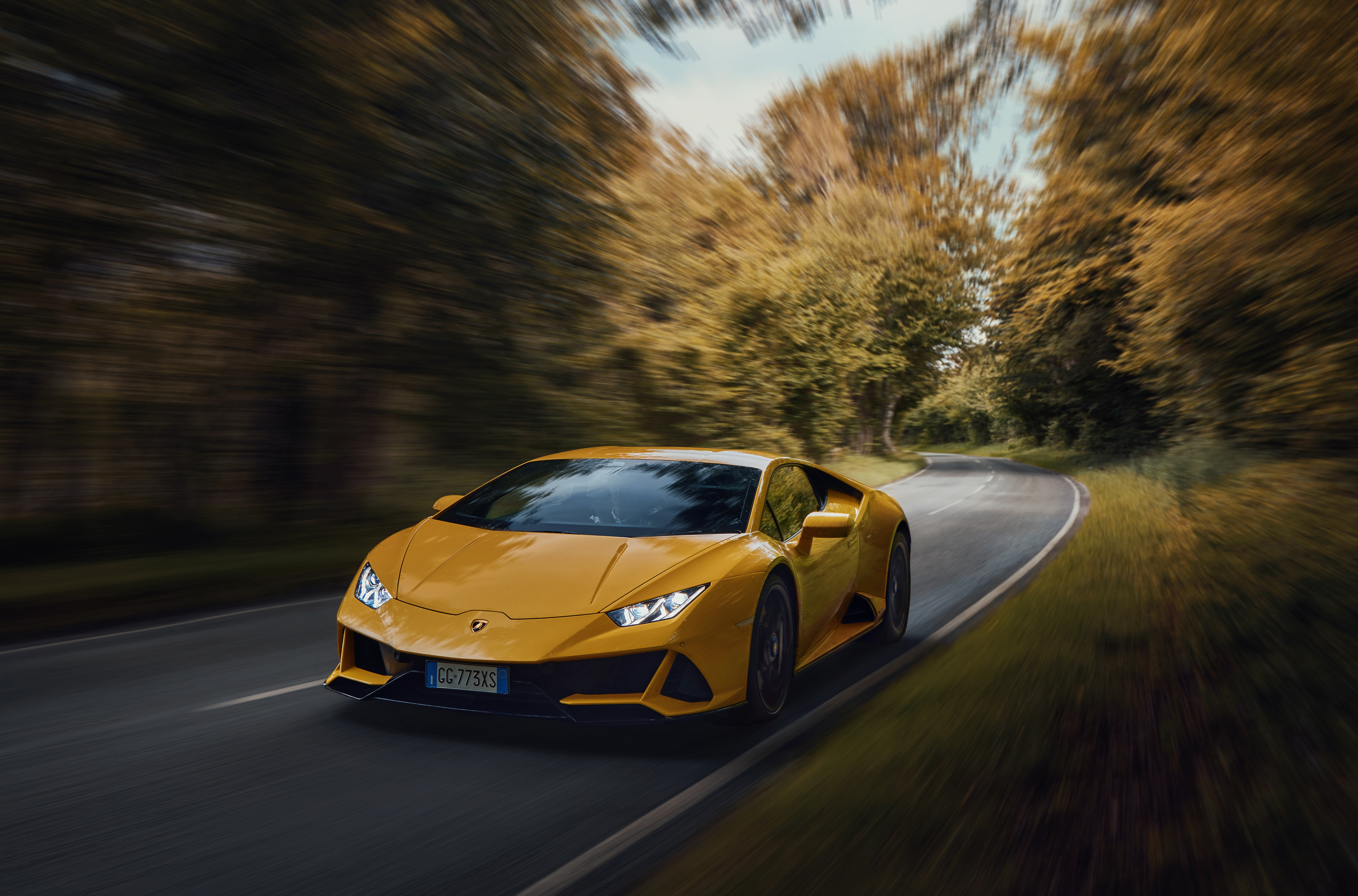 Orange 2022 Lamborghini Huracan Evo drives at high speed down the road