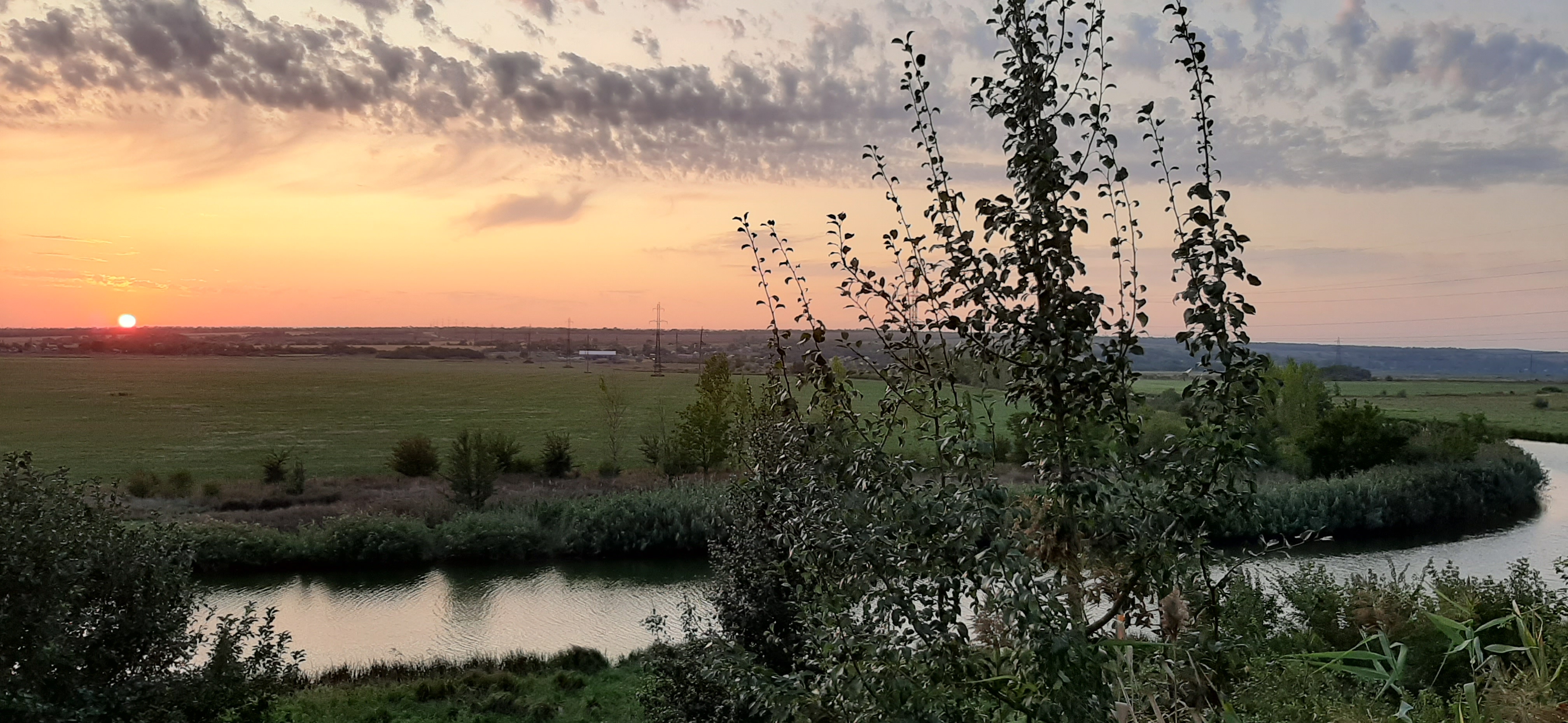 Summer landscape with the river near the village