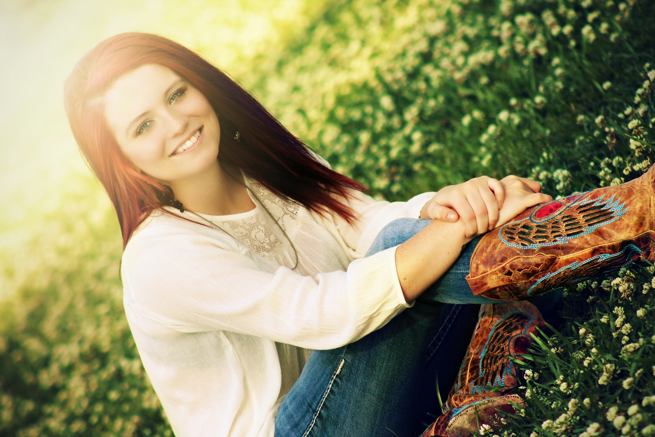 Free photo Portrait of a smiling brunette sitting on the grass