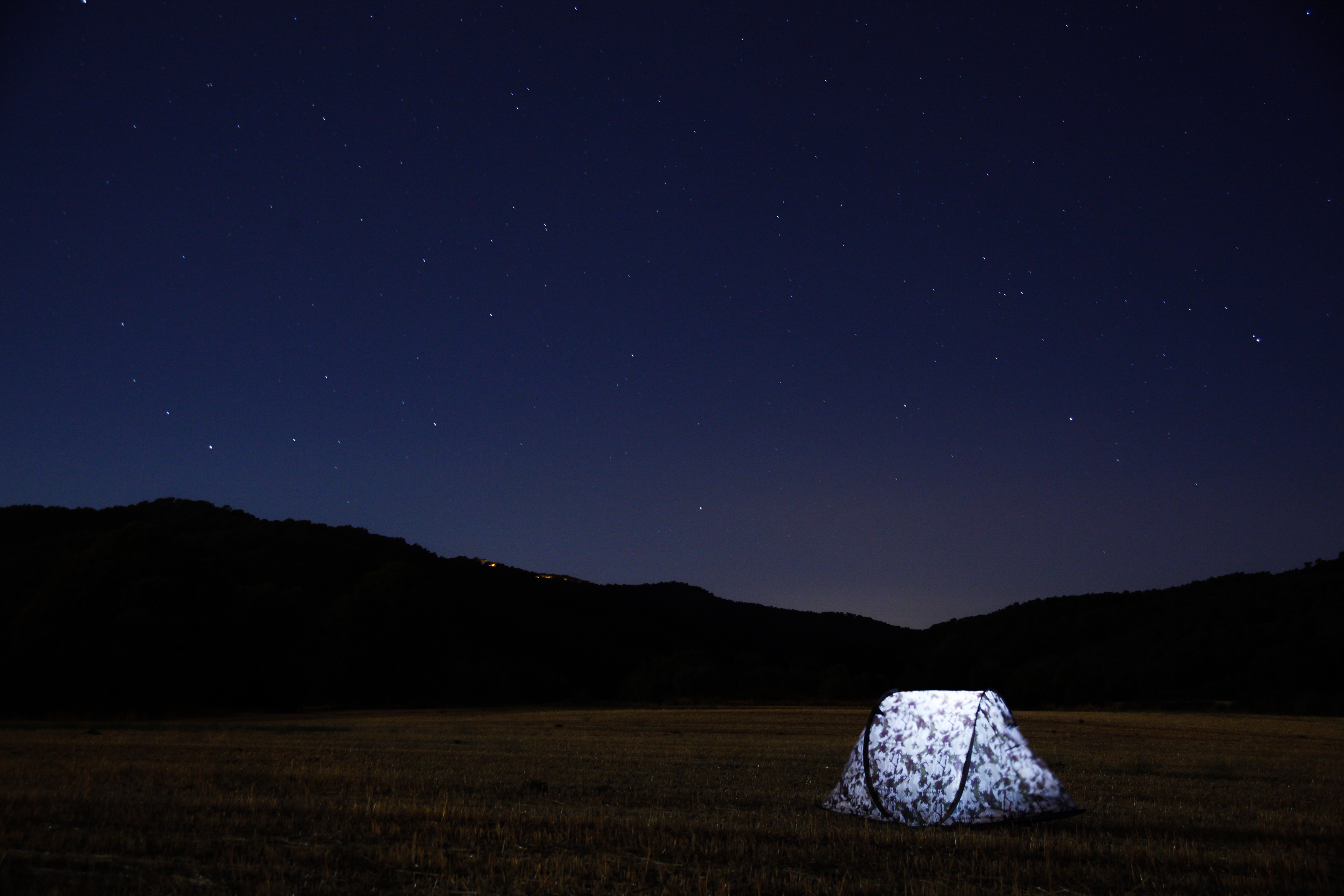 Free photo A glowing tent in the middle of a field