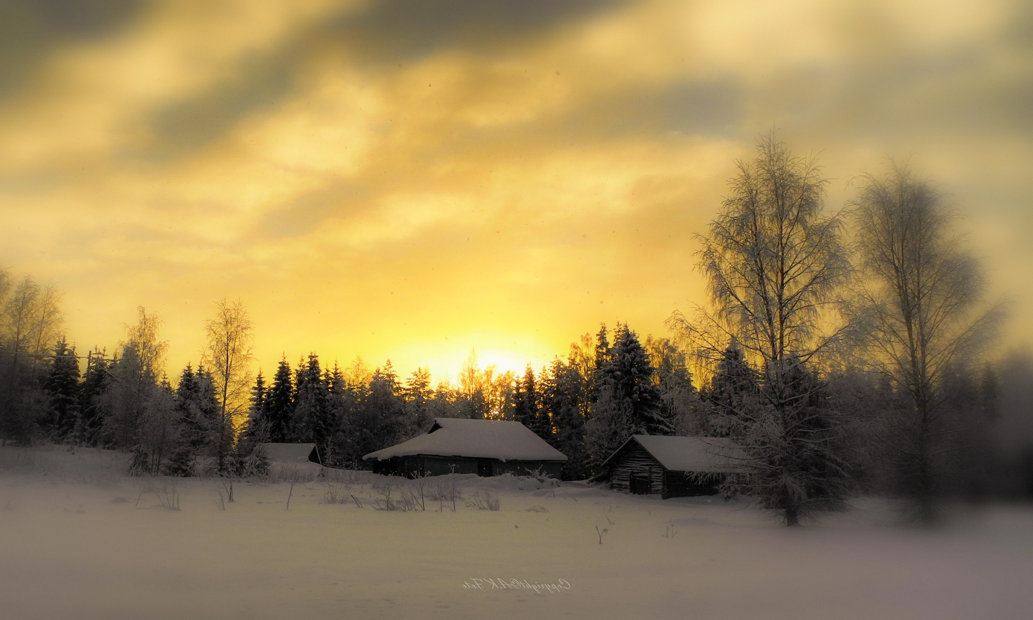 Бесплатное фото Заснеженная деревня на закате: избы, инеевые деревья, небо в золотых облаках.