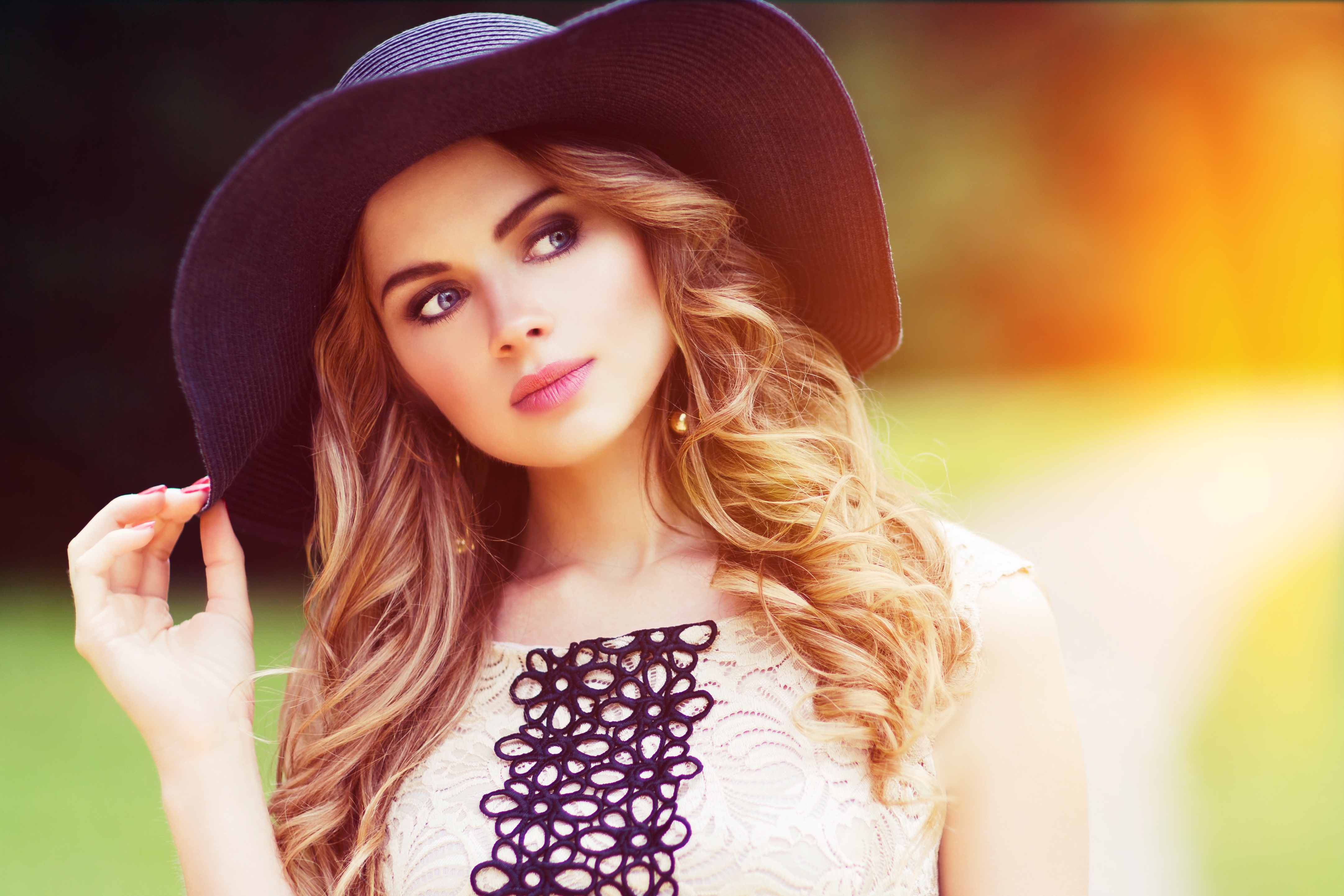 Free photo Beautiful blonde girl in a black hat in sunny weather