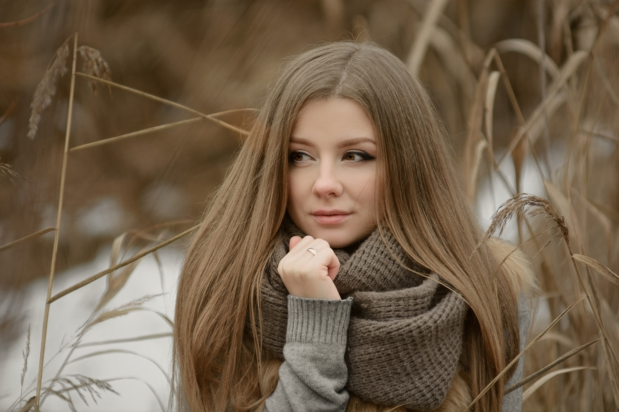 一位棕发女性的肖像，头戴棕色针织冬季围巾