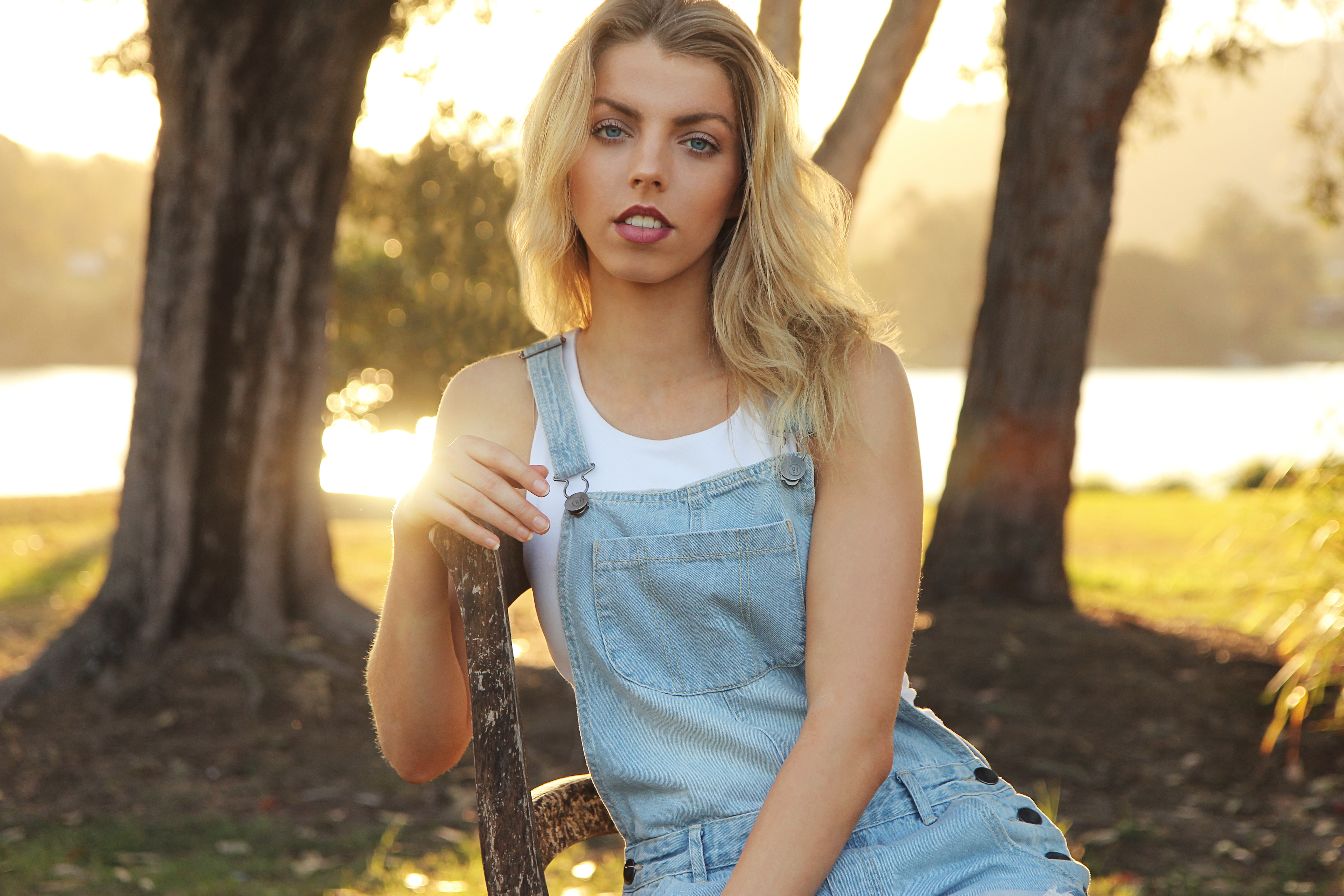 Blonde sitting on an old chair by the river