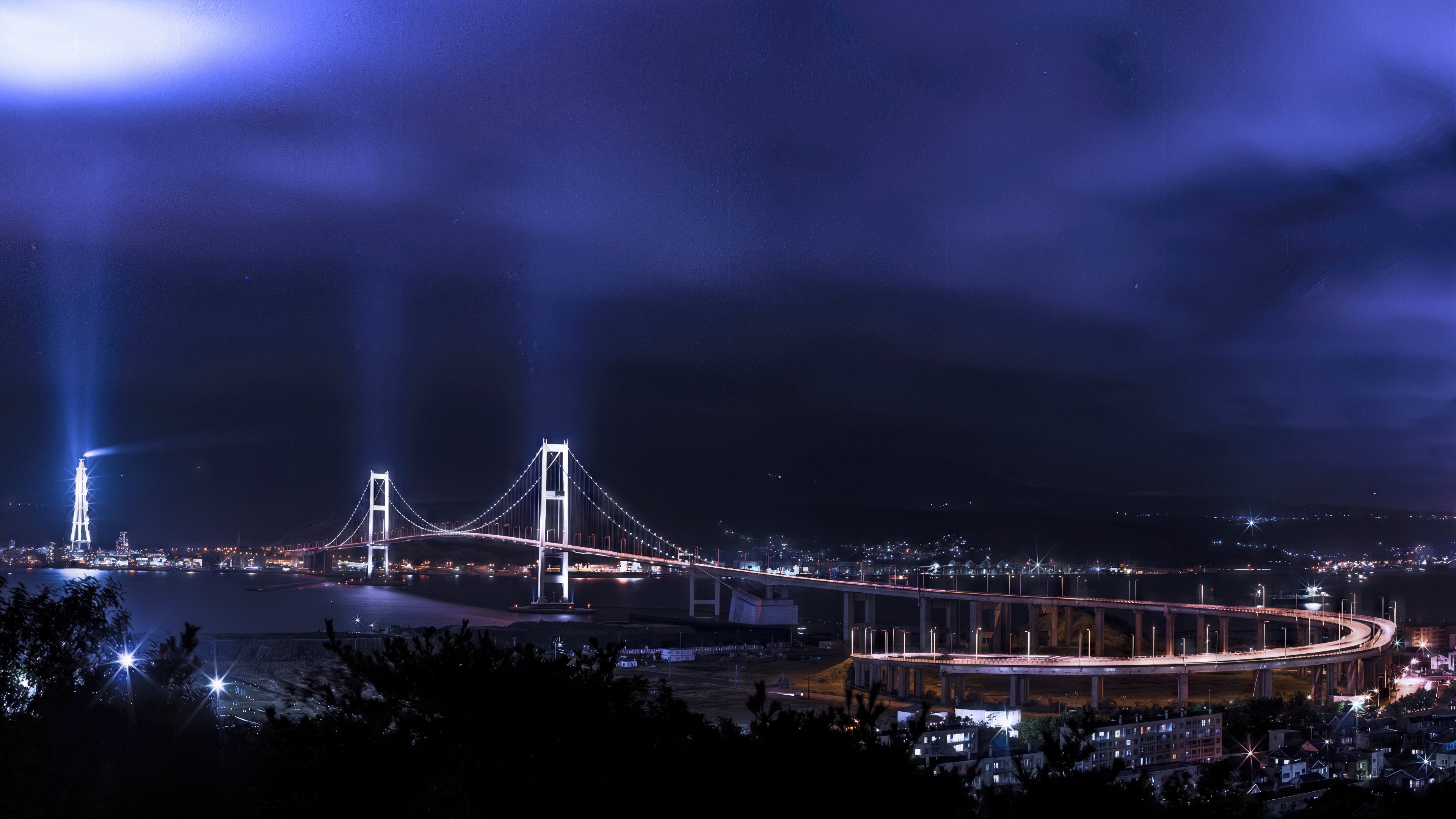 Free photo The hanging bridge in the night illumination over the calm surface of the water.