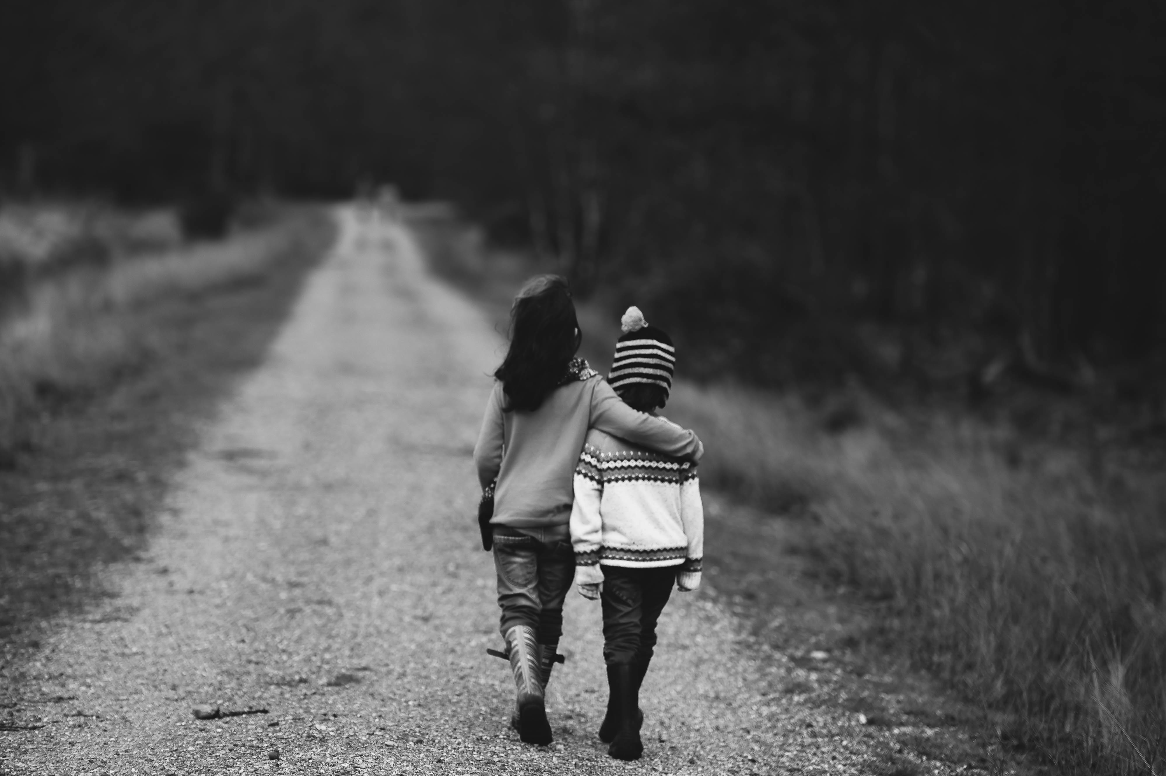 Free photo Children walking along the road in their arms