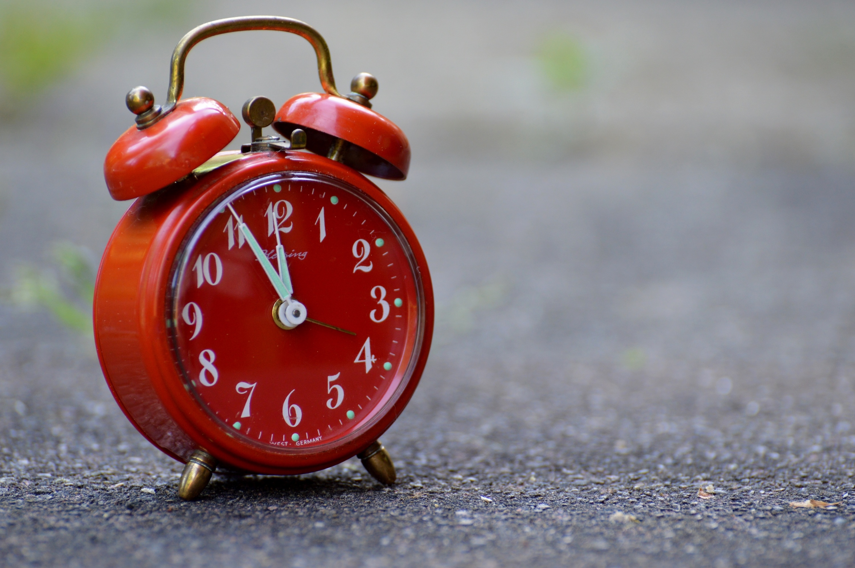 Free photo Red alarm clock on the pavement