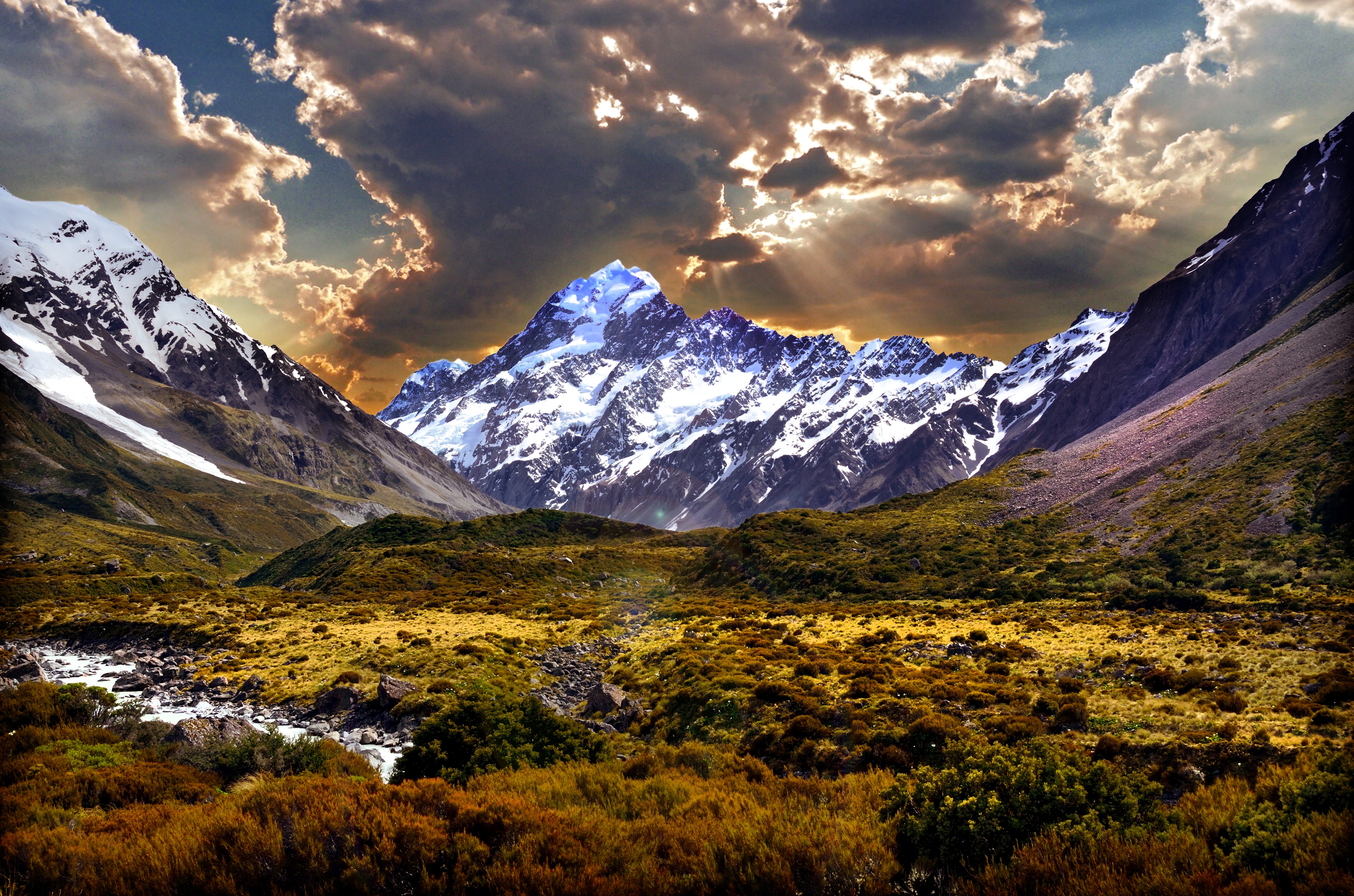 Free photo Glade at the foot of the mountains with snowy peaks