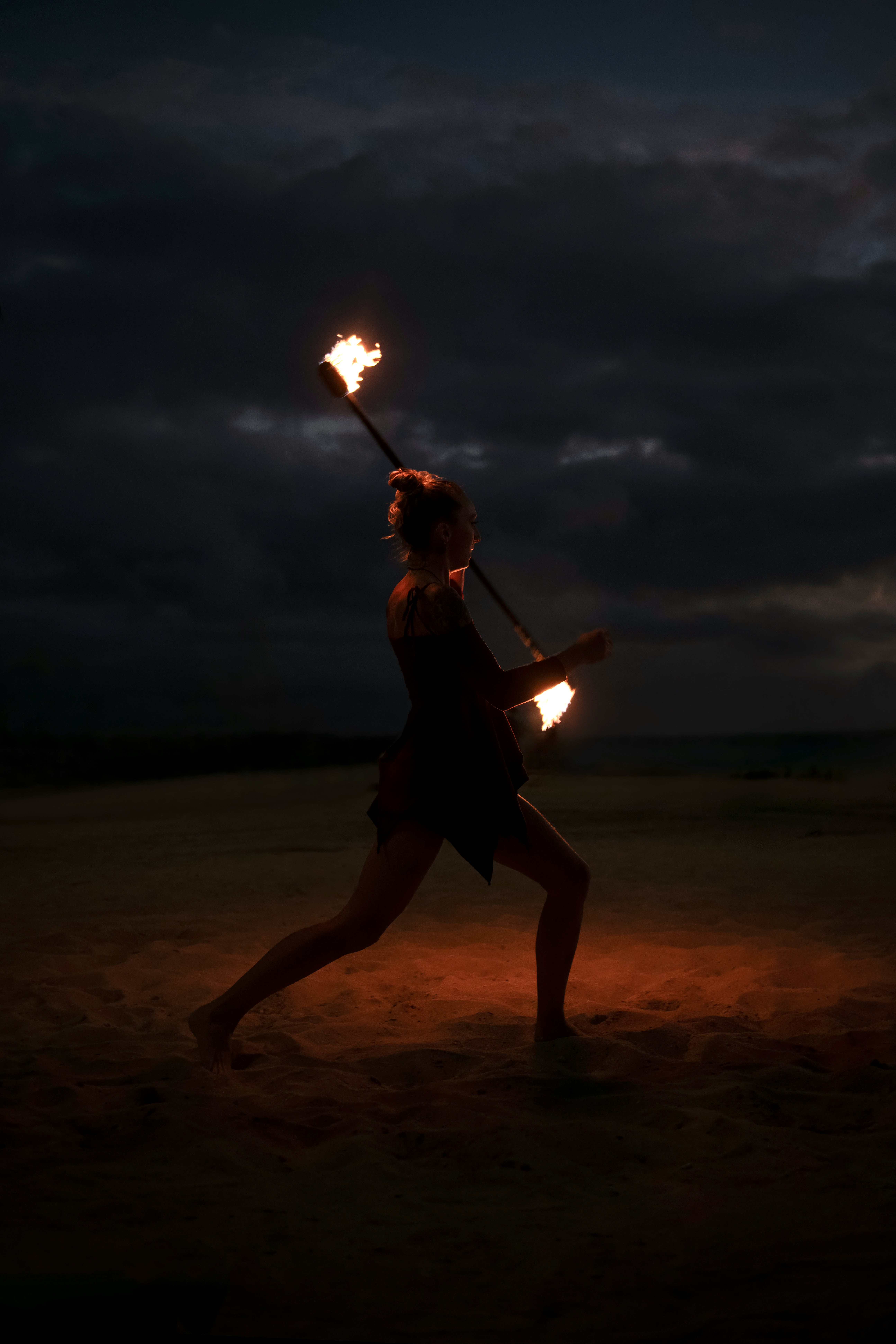 Девушка с факелами, на пляже.