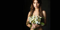 A girl and daisies on a dark background