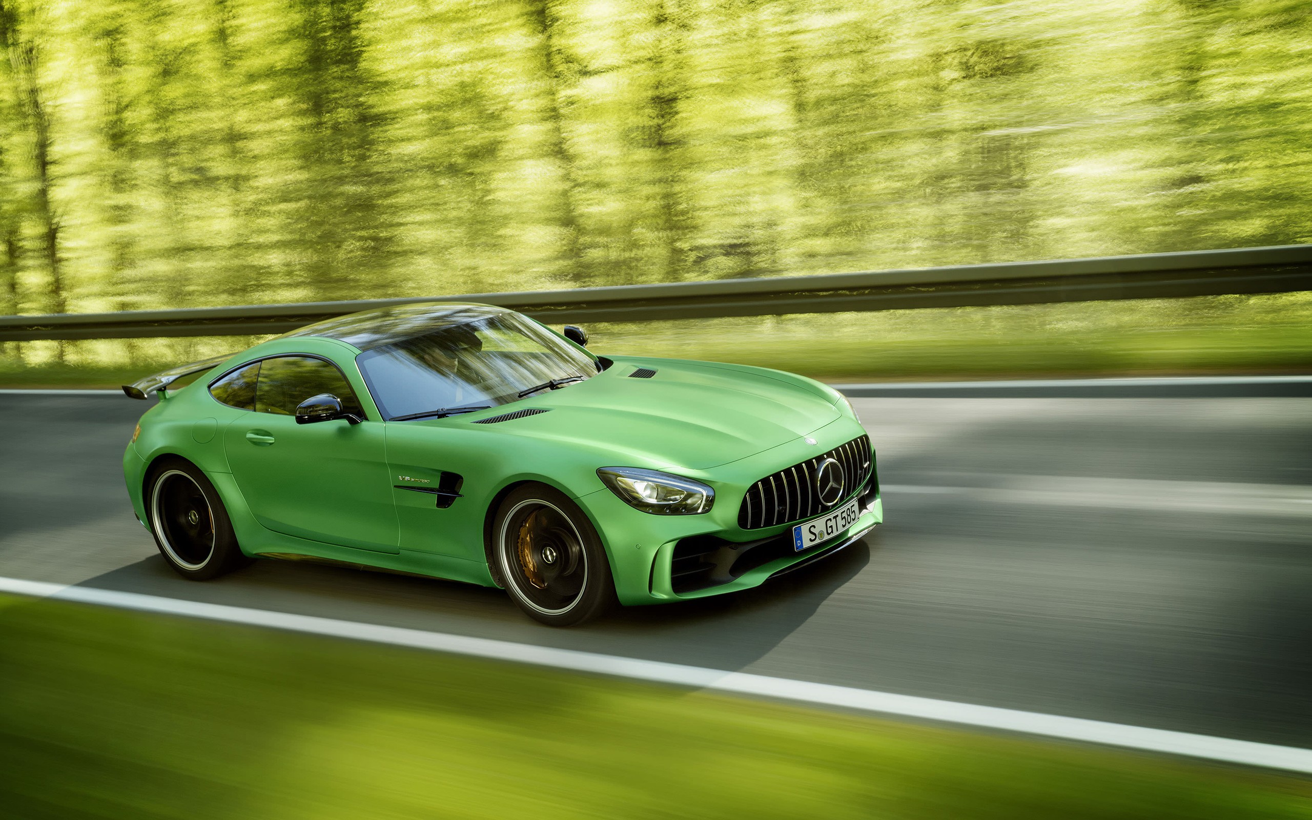 Бесплатное фото Зеленый Mercedes amg gt r едет по лесной дороге