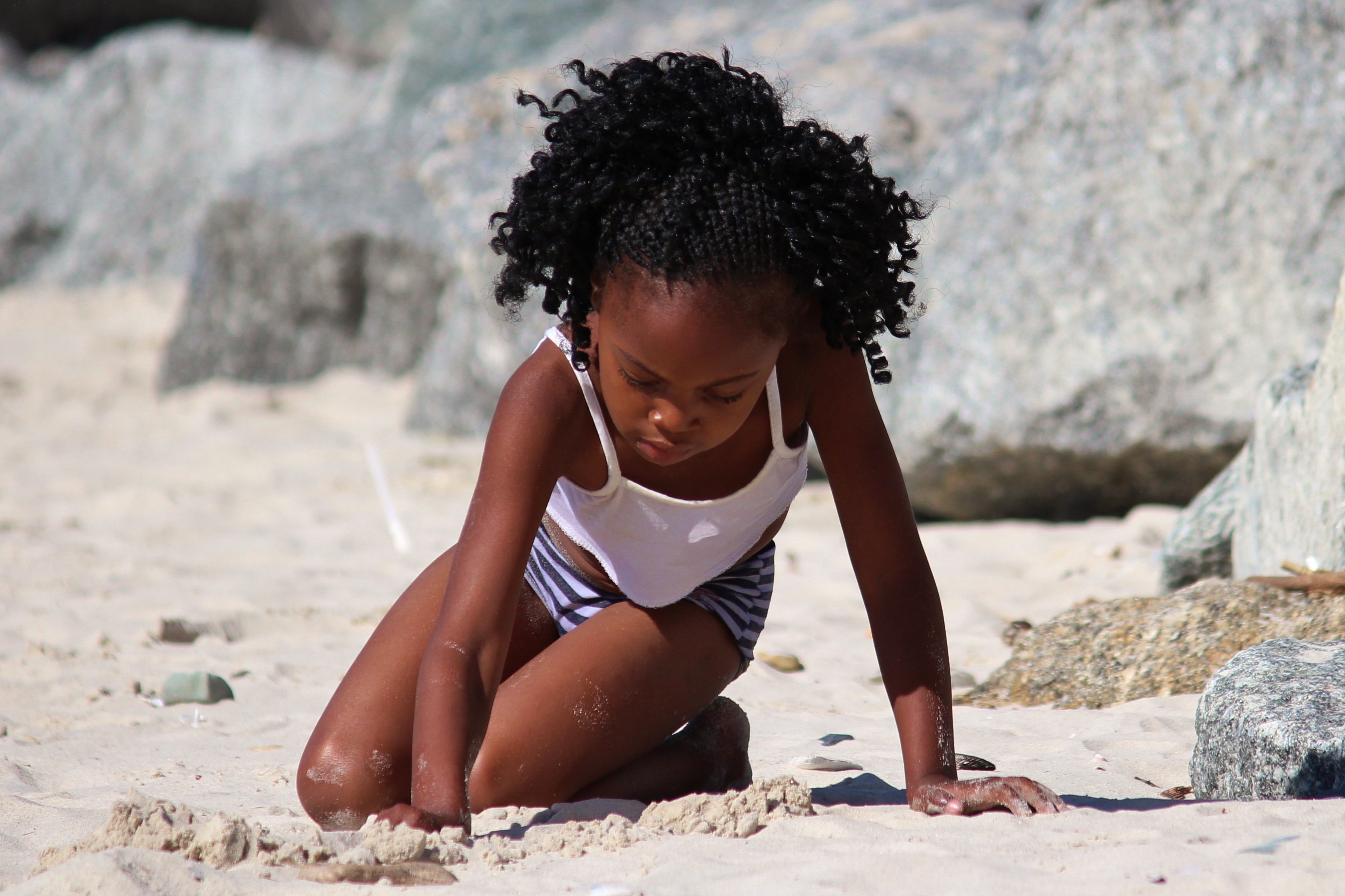 Black girl playing with sand in South Africa
