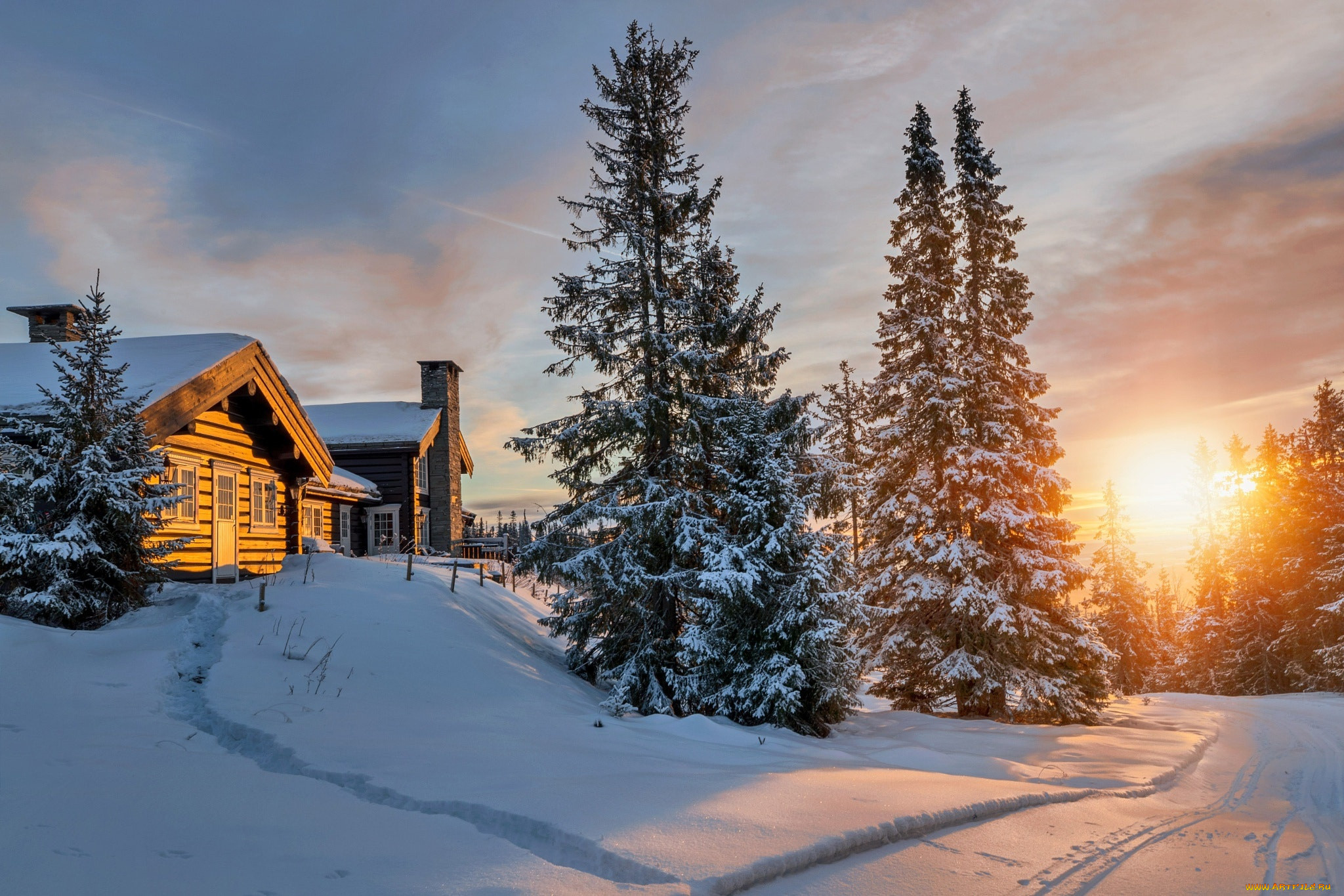 Wooden cabin in the winter forest at sunset