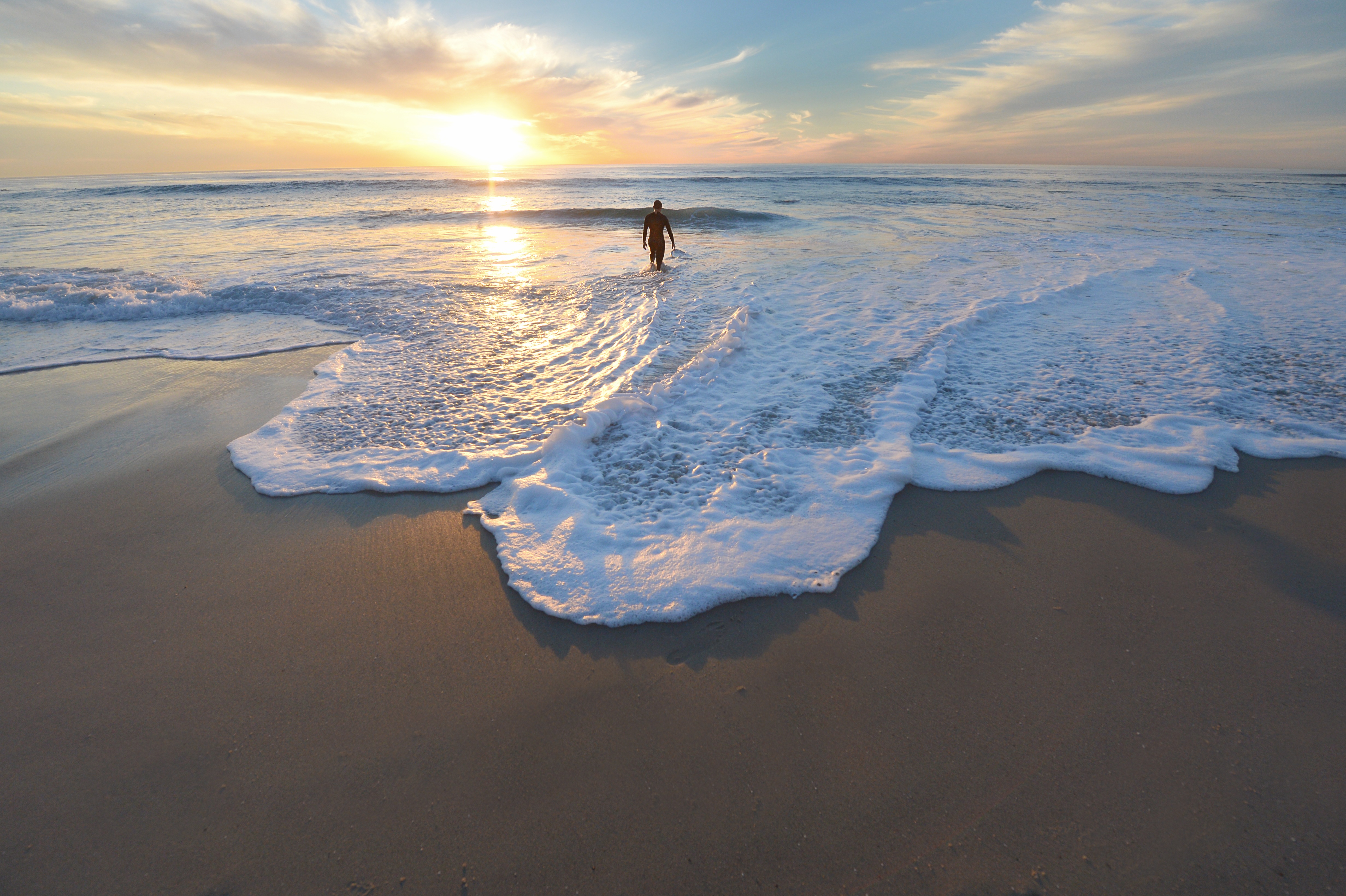 Free photo A surfer on the beach enters the water