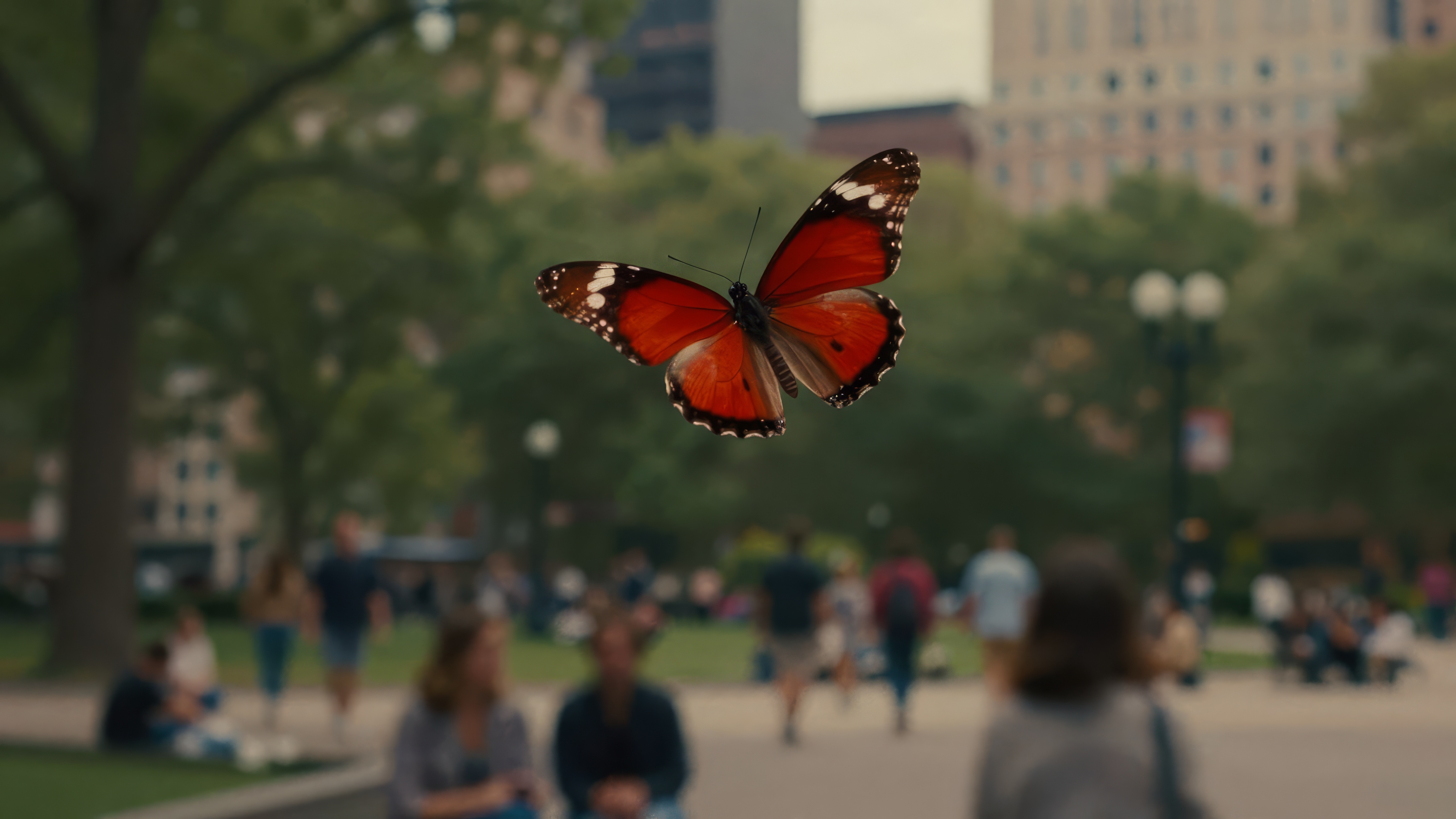 Бесплатное фото Красная бабочка, парящая в воздухе, в то время как люди проходят мимо