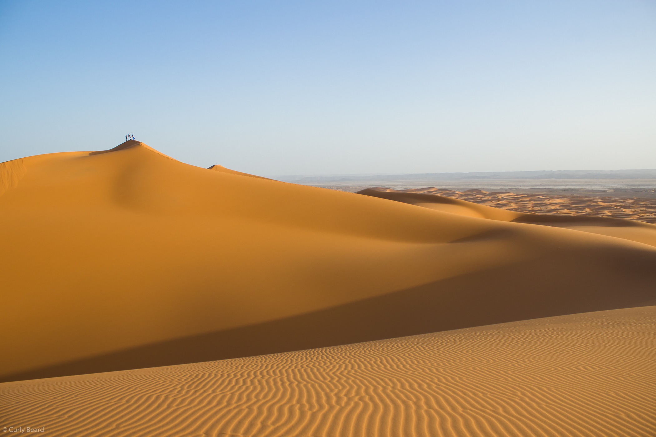 Free photo A desert with people on a hill