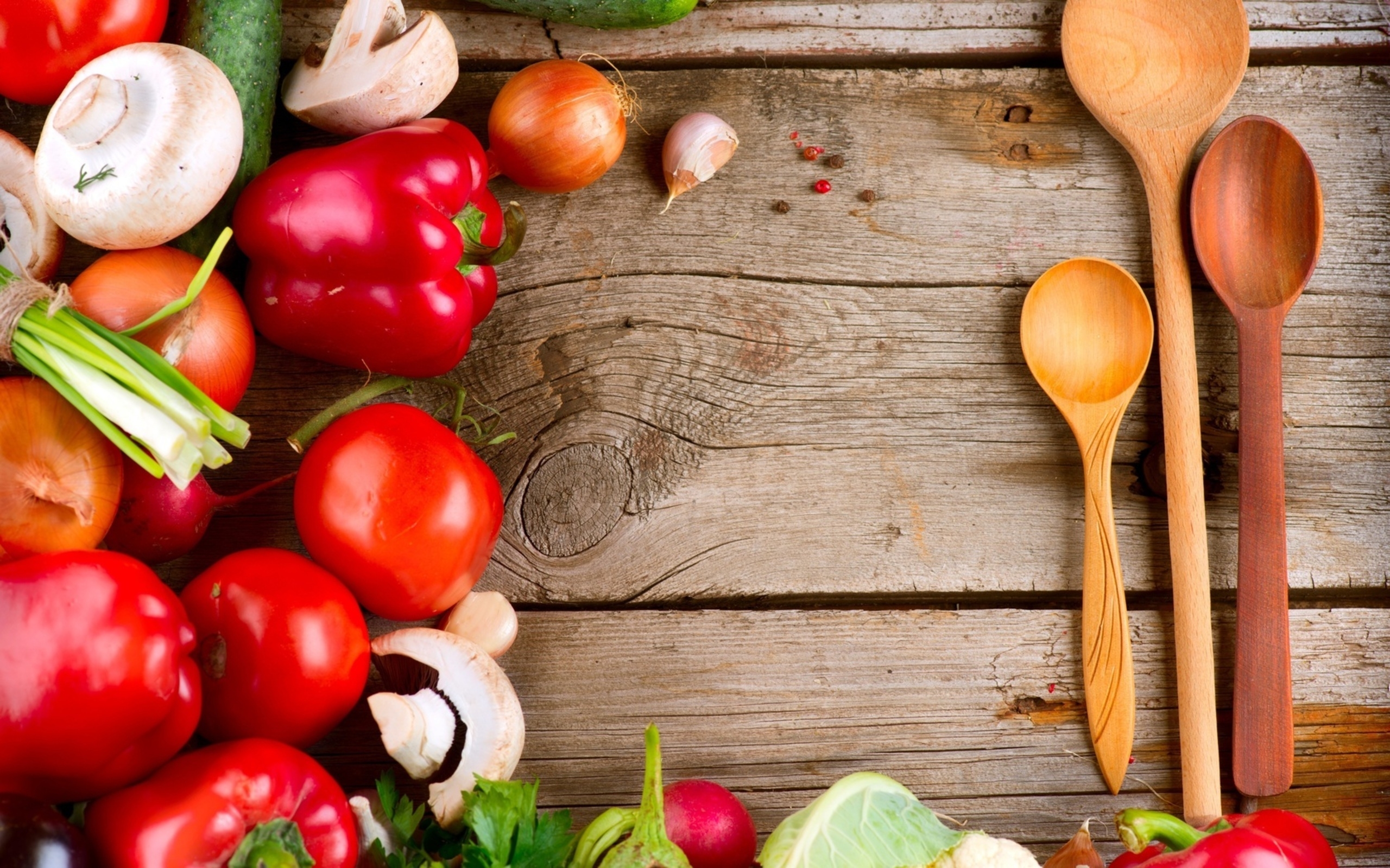 Free photo Fresh vegetables with wooden spoons on a wooden background