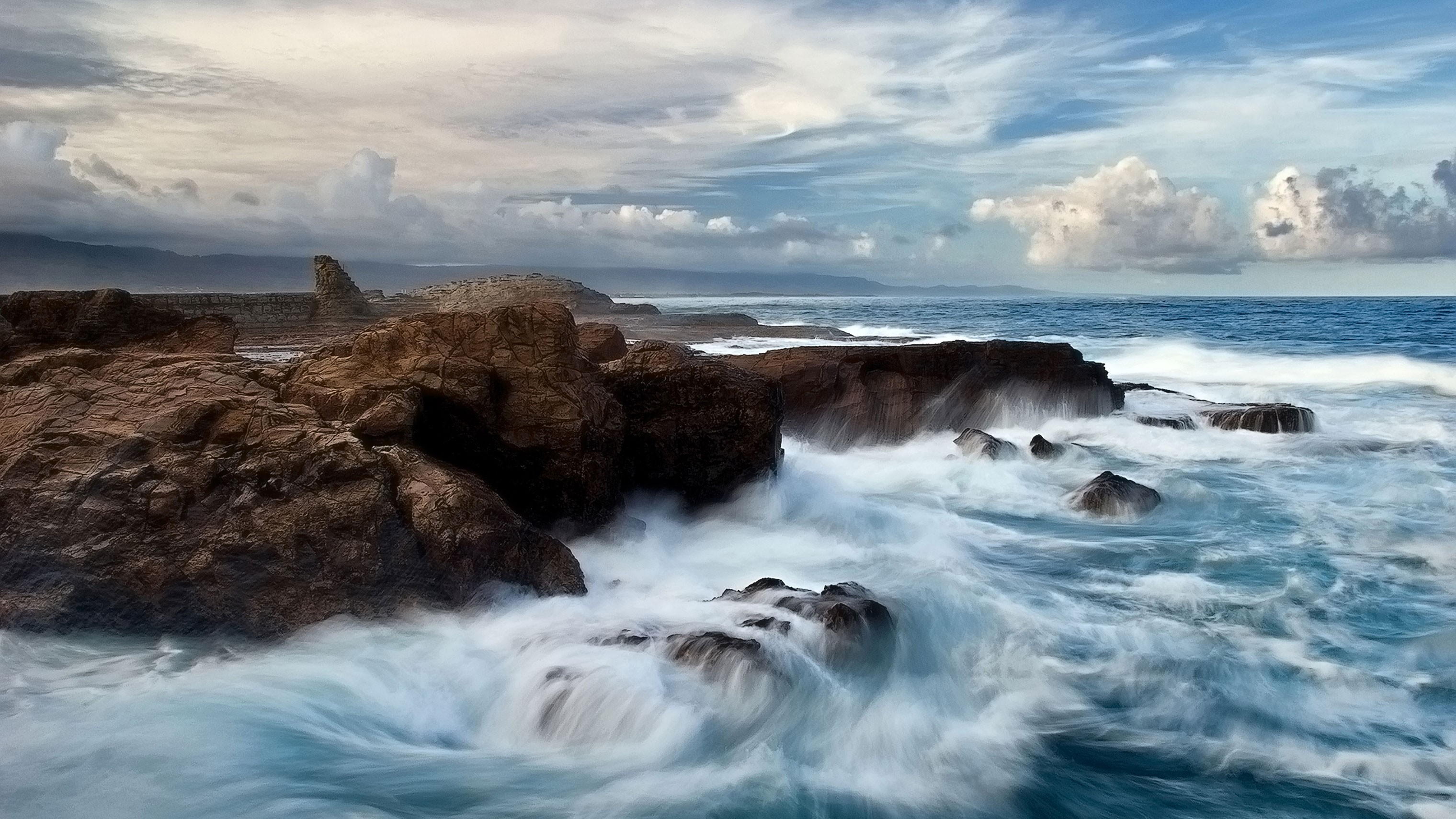 Free photo Waves crash against the rocks on the seashore