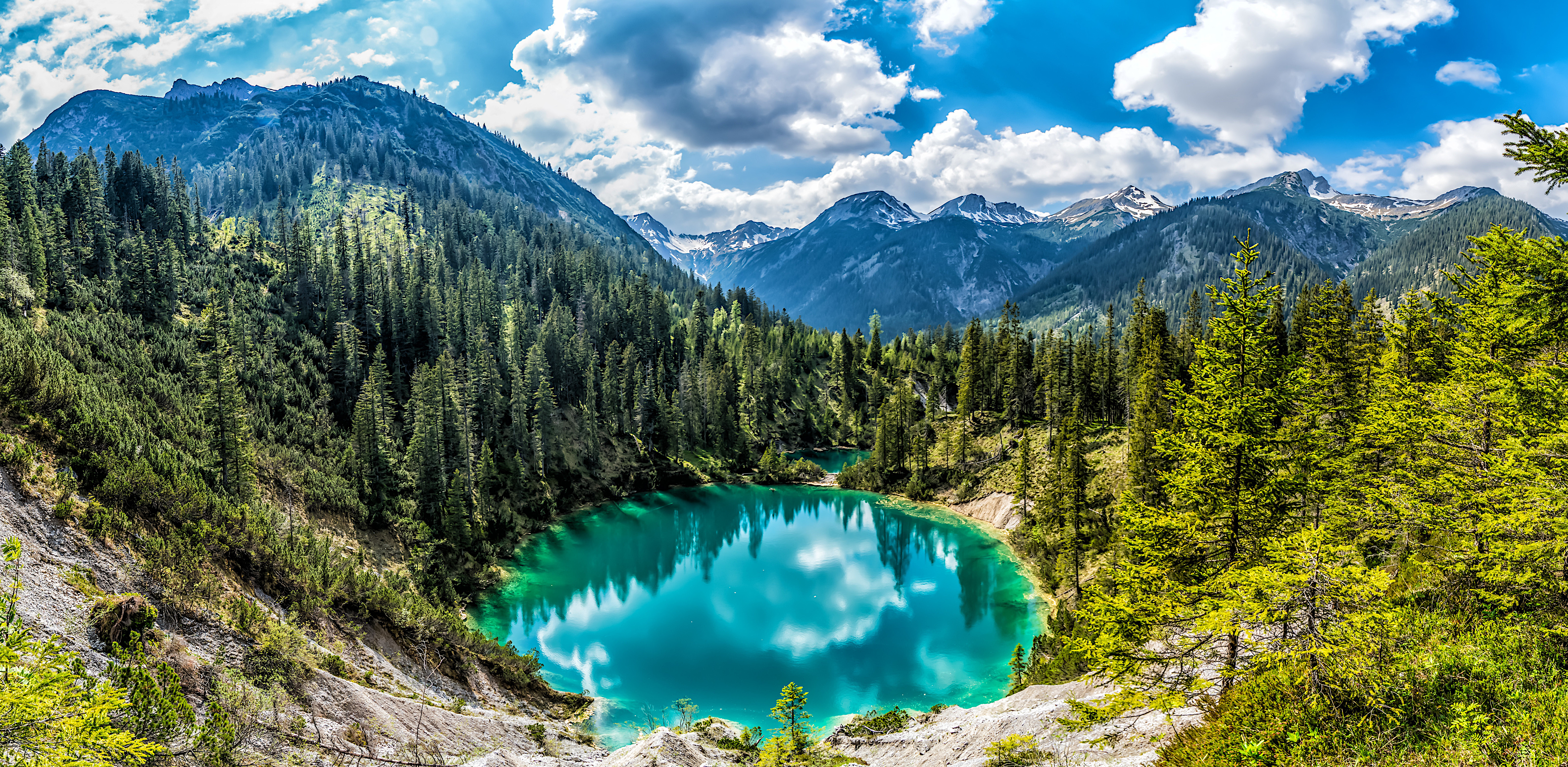 Free photo A round lake with blue water in the middle of the forest