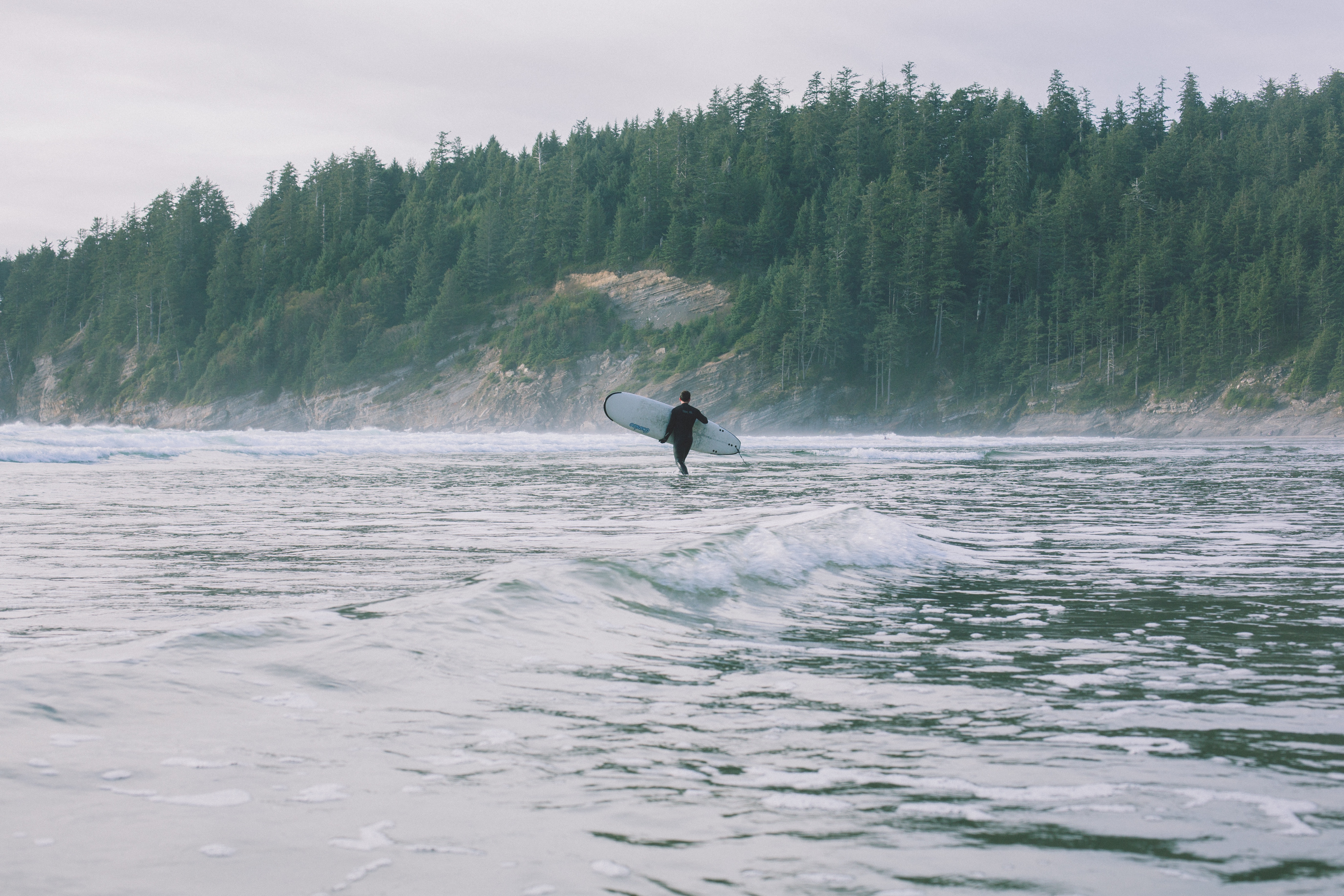 Free photo A surfer with a board walks on the beach