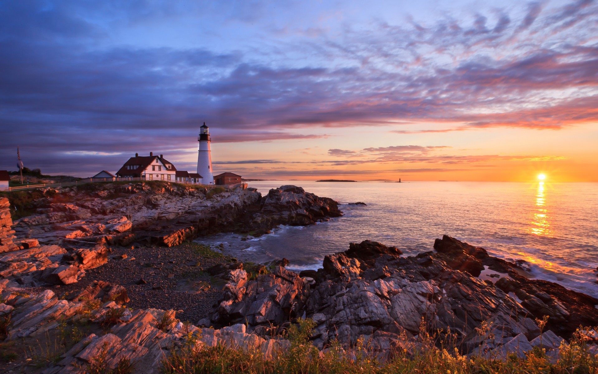 Free photo House next to the lighthouse on the beach during sunset