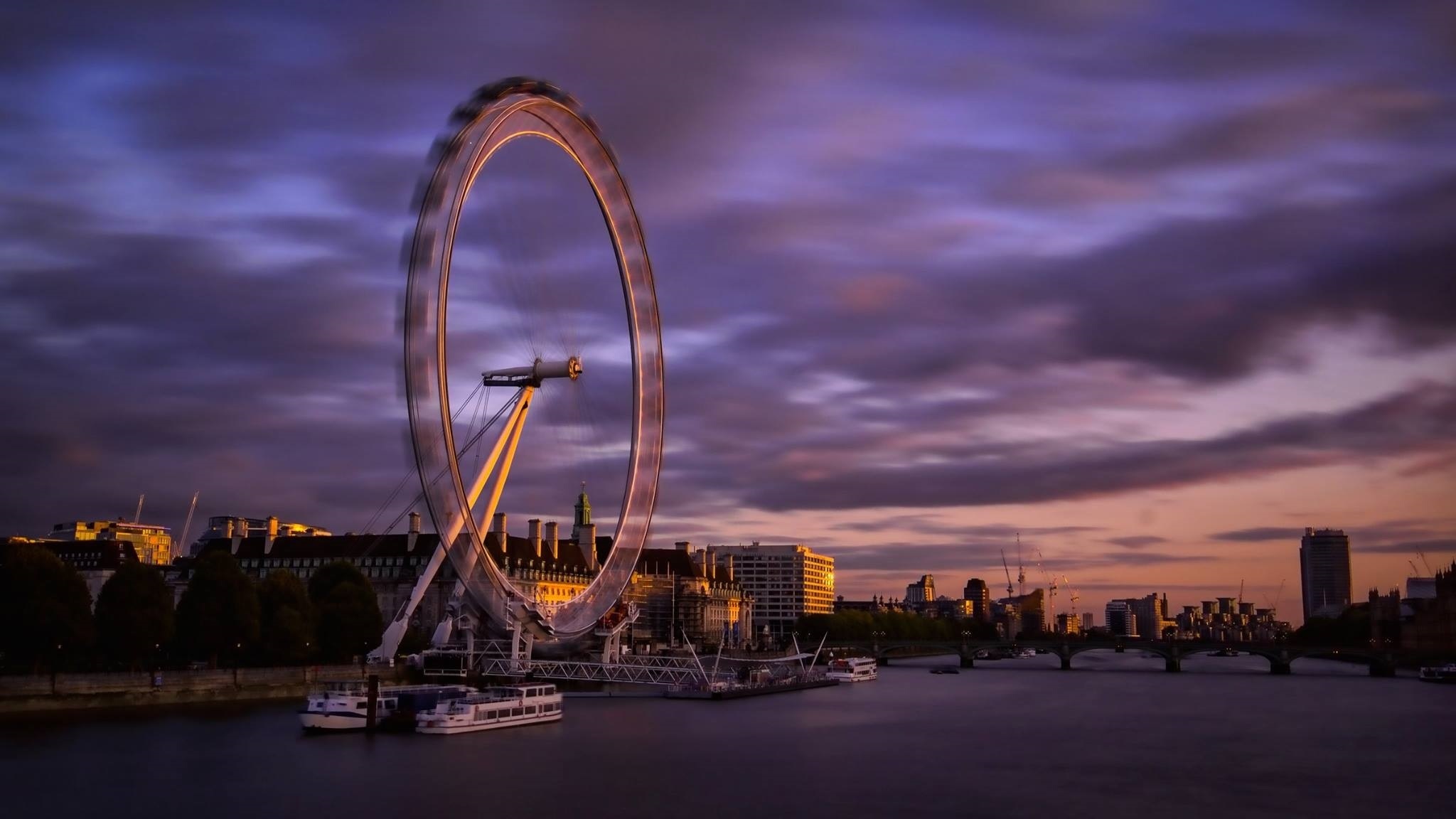 Free photo Ferris wheel on the river bank during sunset