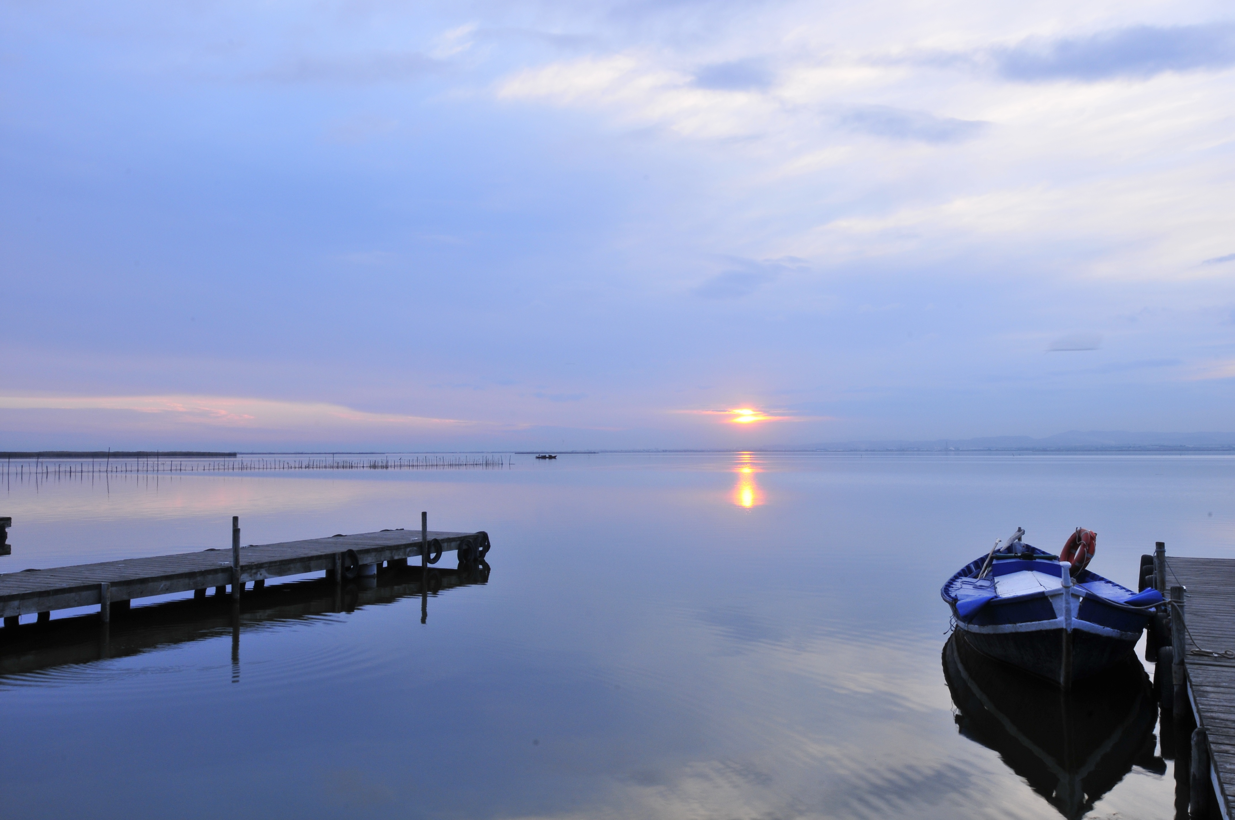 Free photo Sunrise on the lake at the marina with the wooden boat