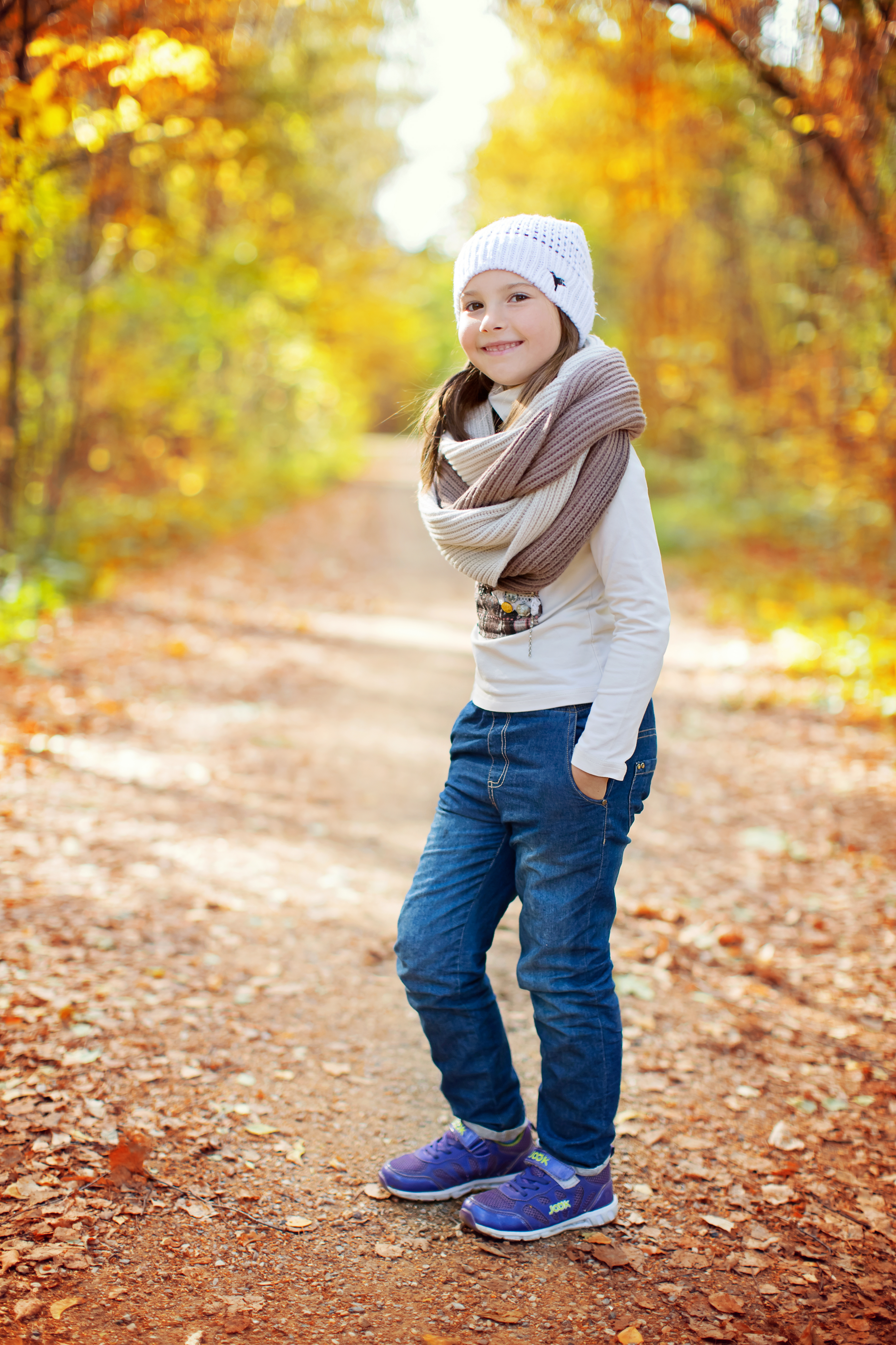 美丽的女孩，围着围巾，戴着白帽，在秋天的森林里，照片