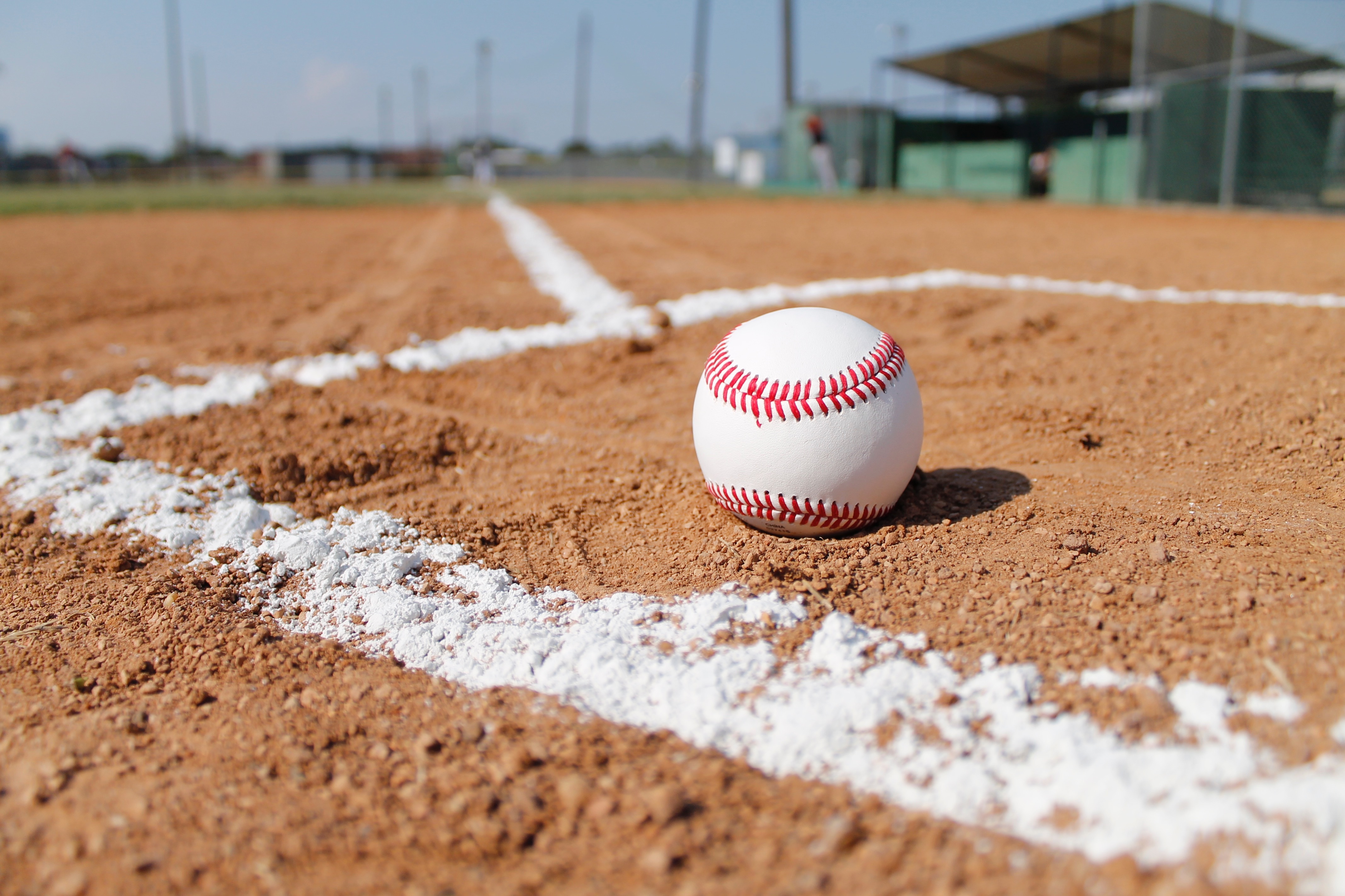 Free photo A baseball lies on the red sand