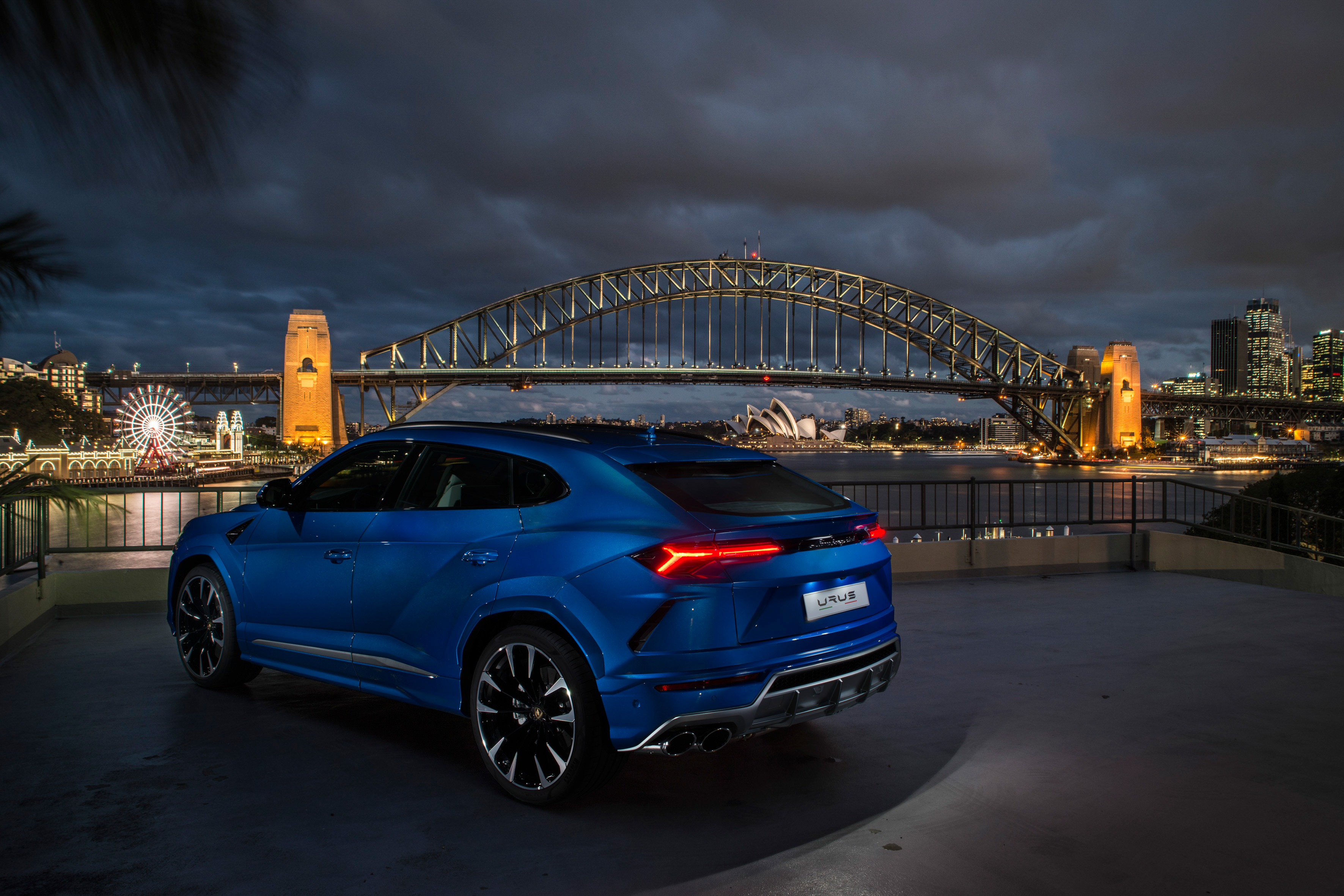Бесплатное фото Синий Lamborghini Urus на фоне большого моста