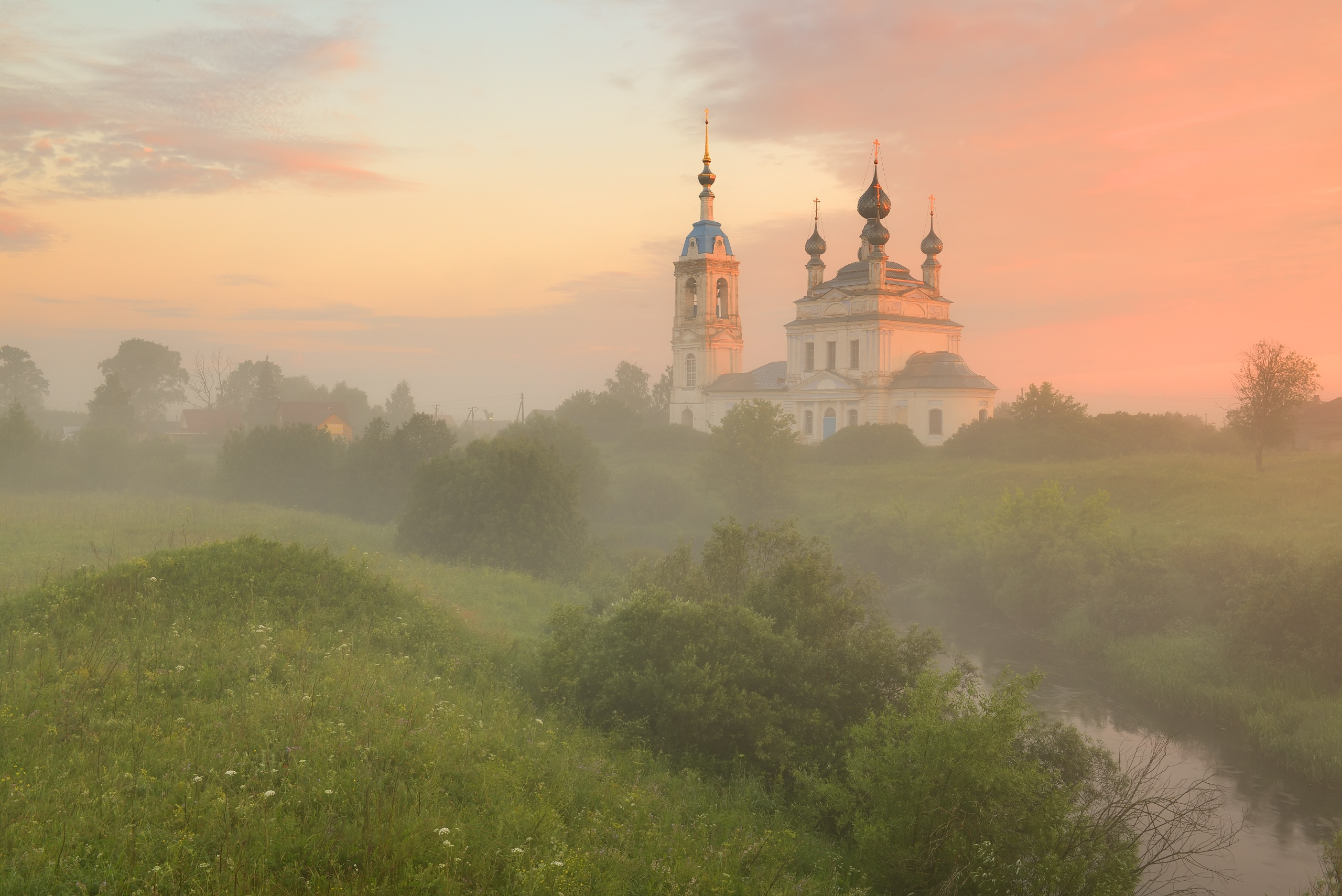 Бесплатное фото Вид на храм через туман на вечерней лужайке