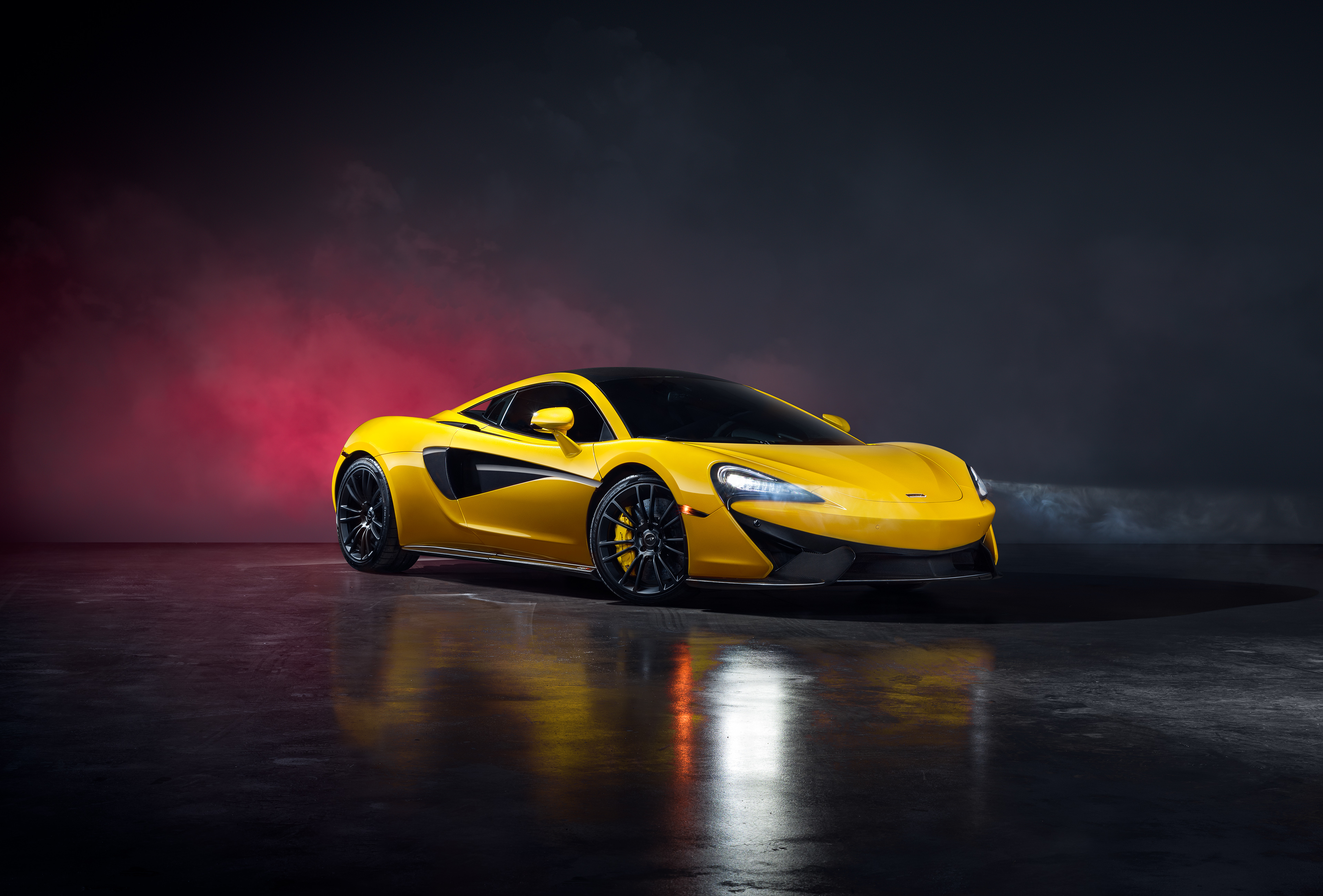 Бесплатное фото Желтый Mclaren 570S Spider в черном дымном помещении