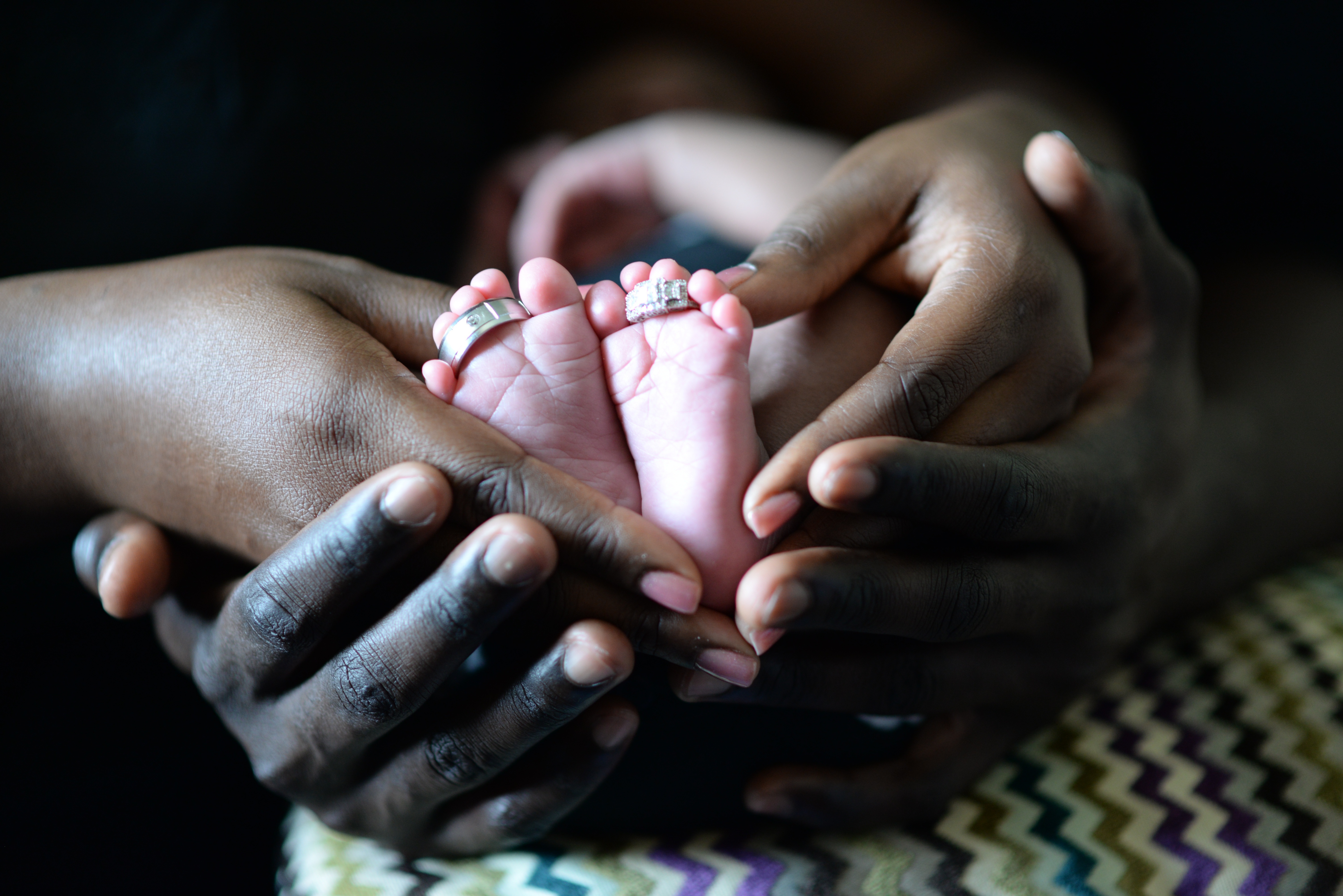 Free photo The baby`s feet in the hands of the mother and father