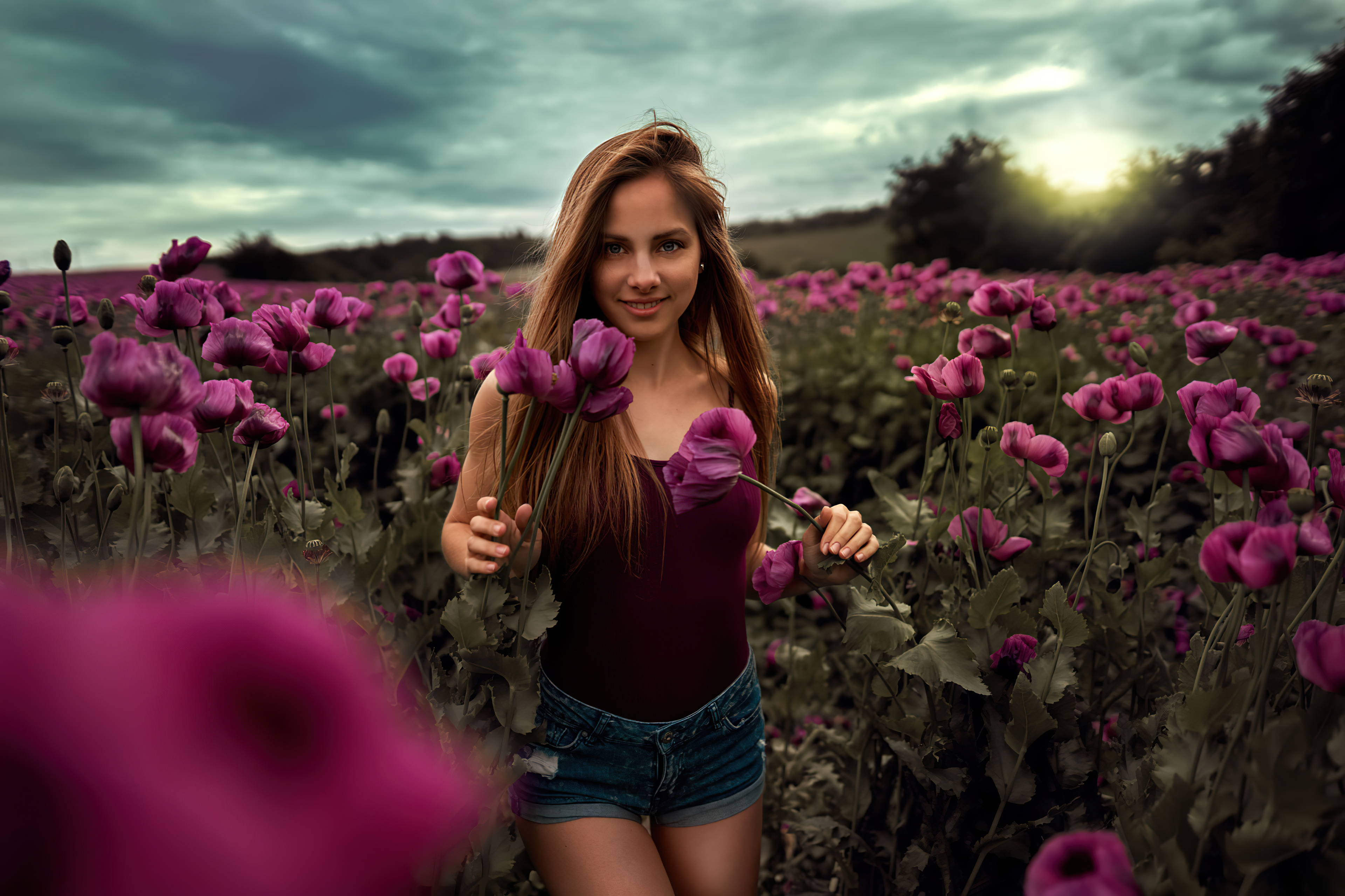 Dark-haired girl walking through a field of purple flowers