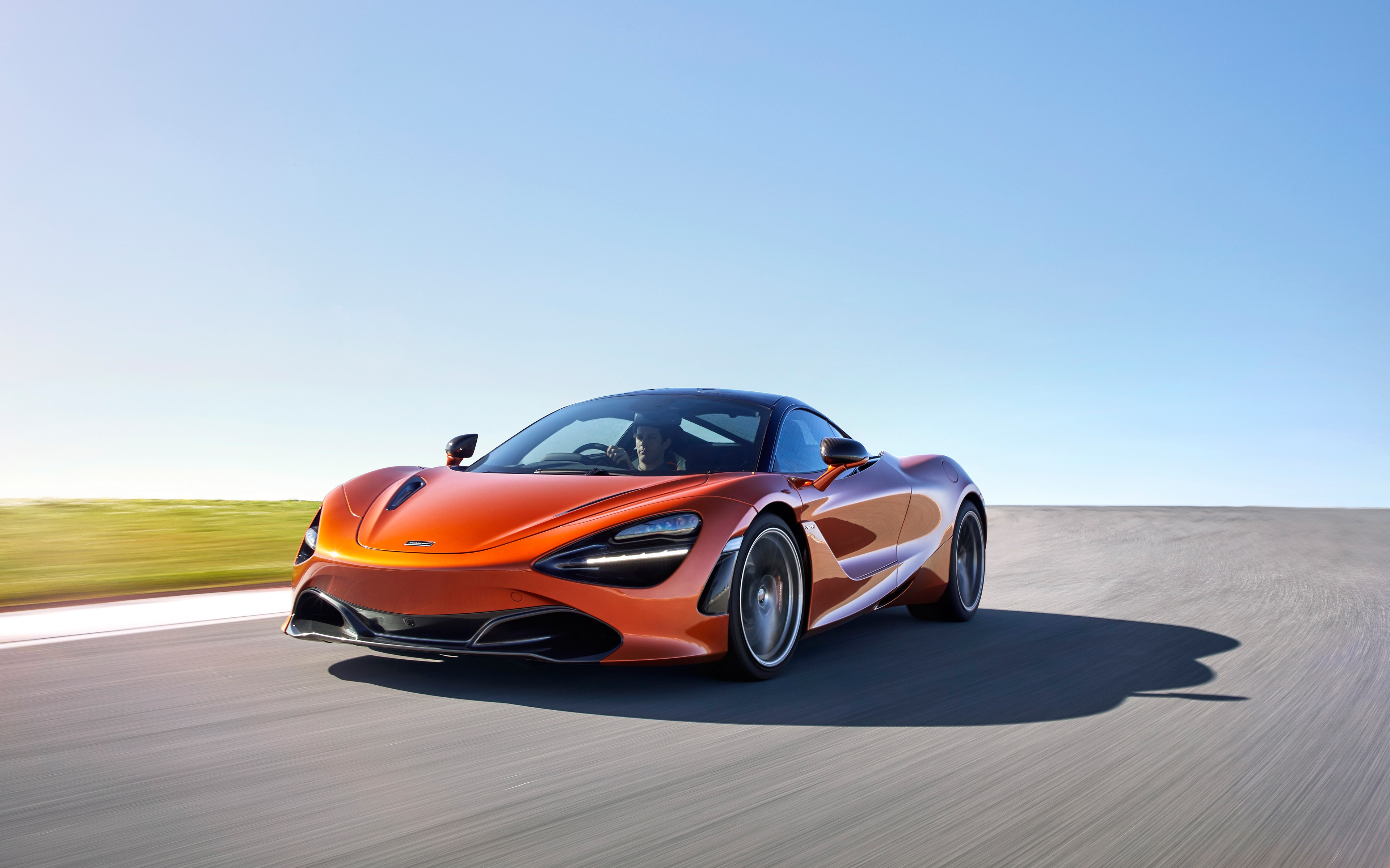 Бесплатное фото Оранжевый mclaren 720s едет на большой скорости