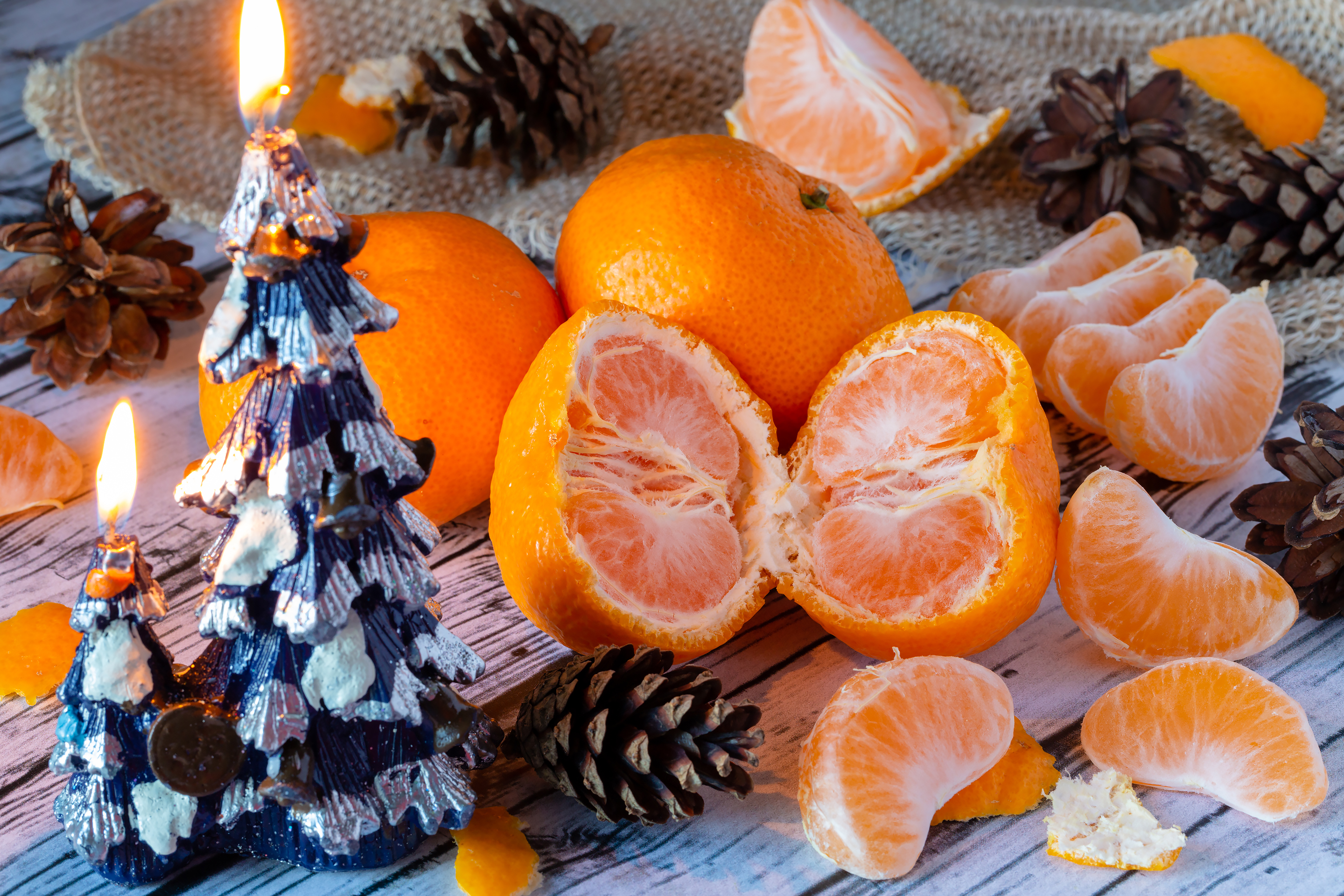 Tangerines and a candle burning Christmas tree.