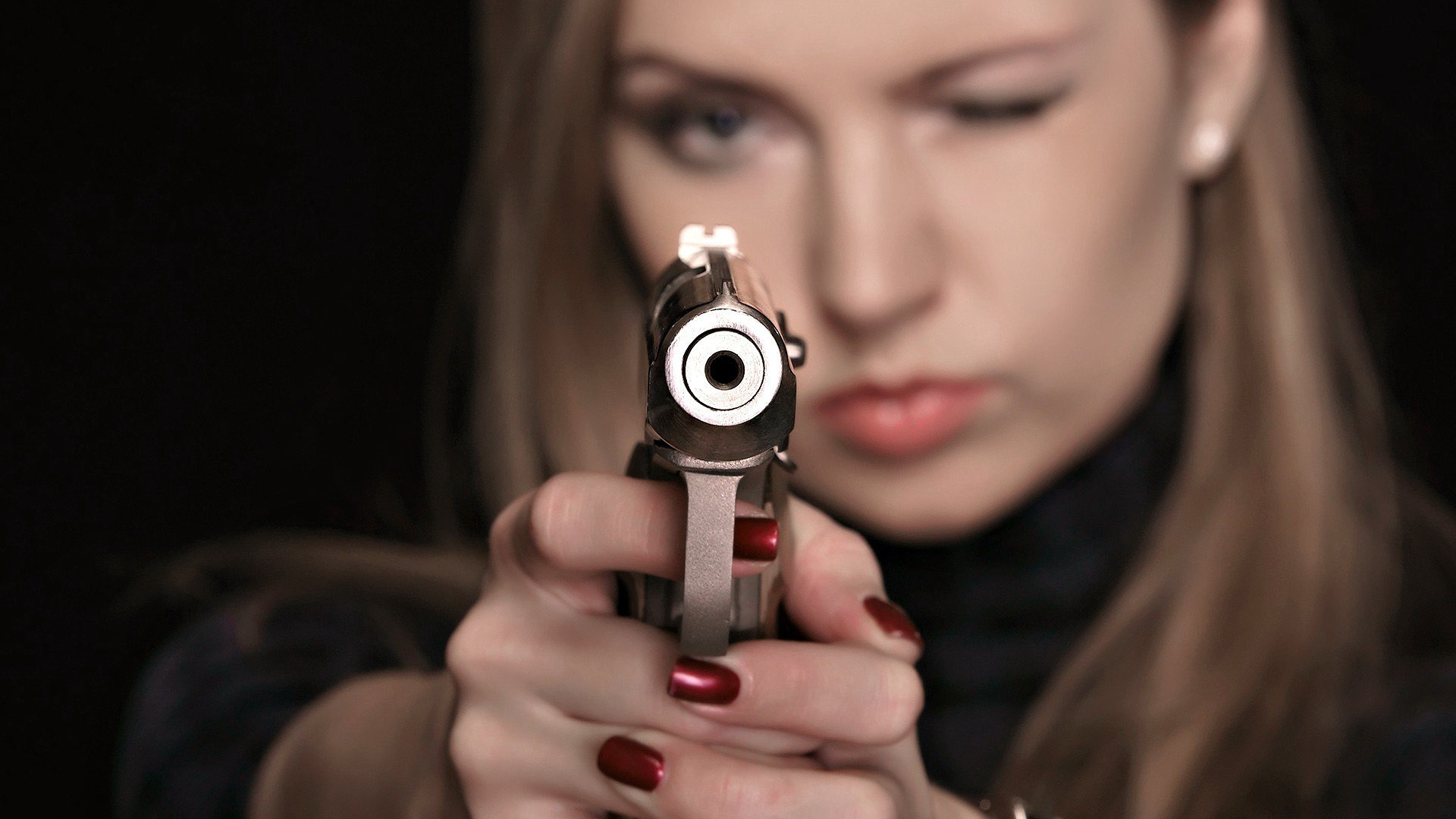 Бесплатное фото Девушка целиться из блестящего пистолета