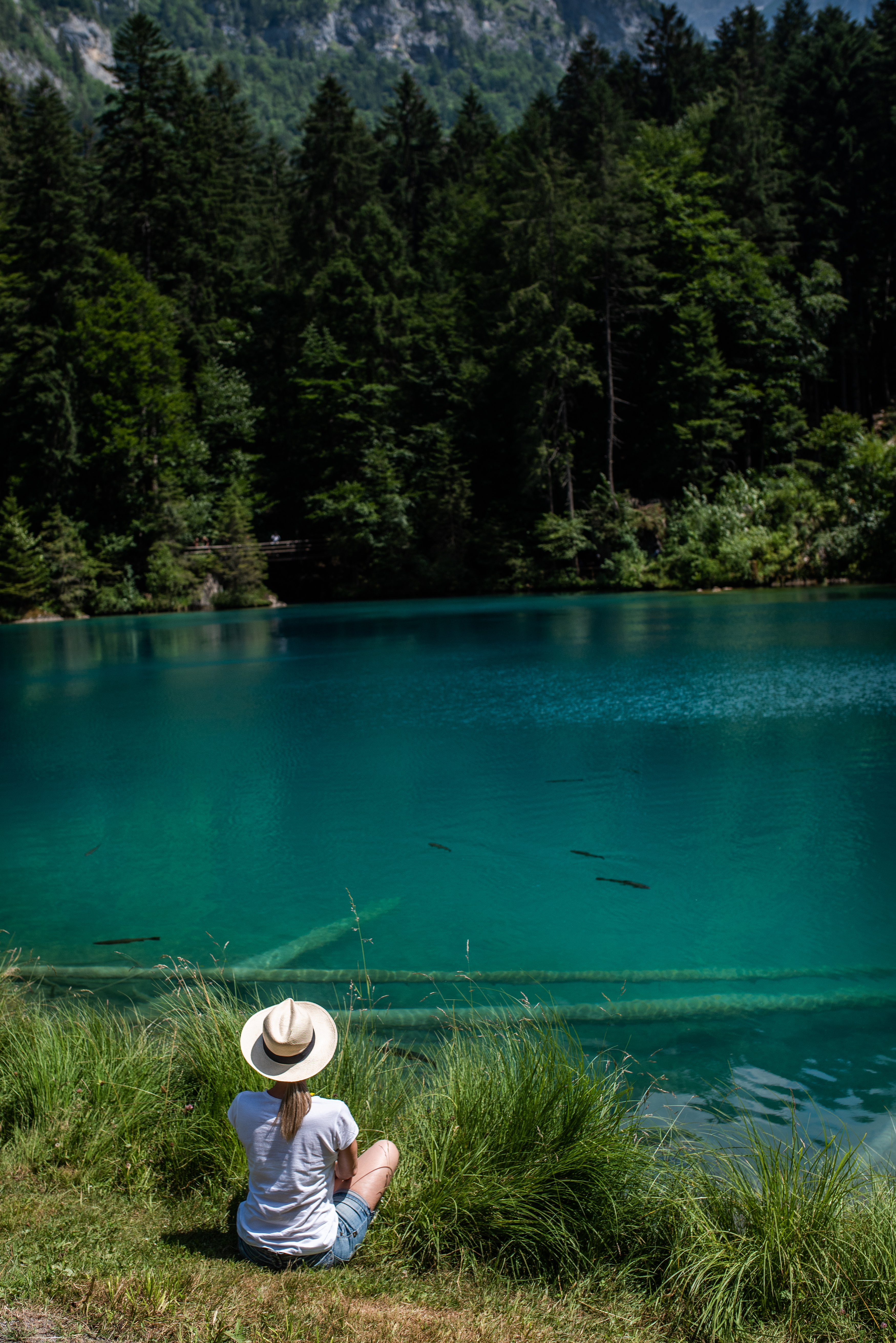 Free photo A girl meditates by a lake of blue water.