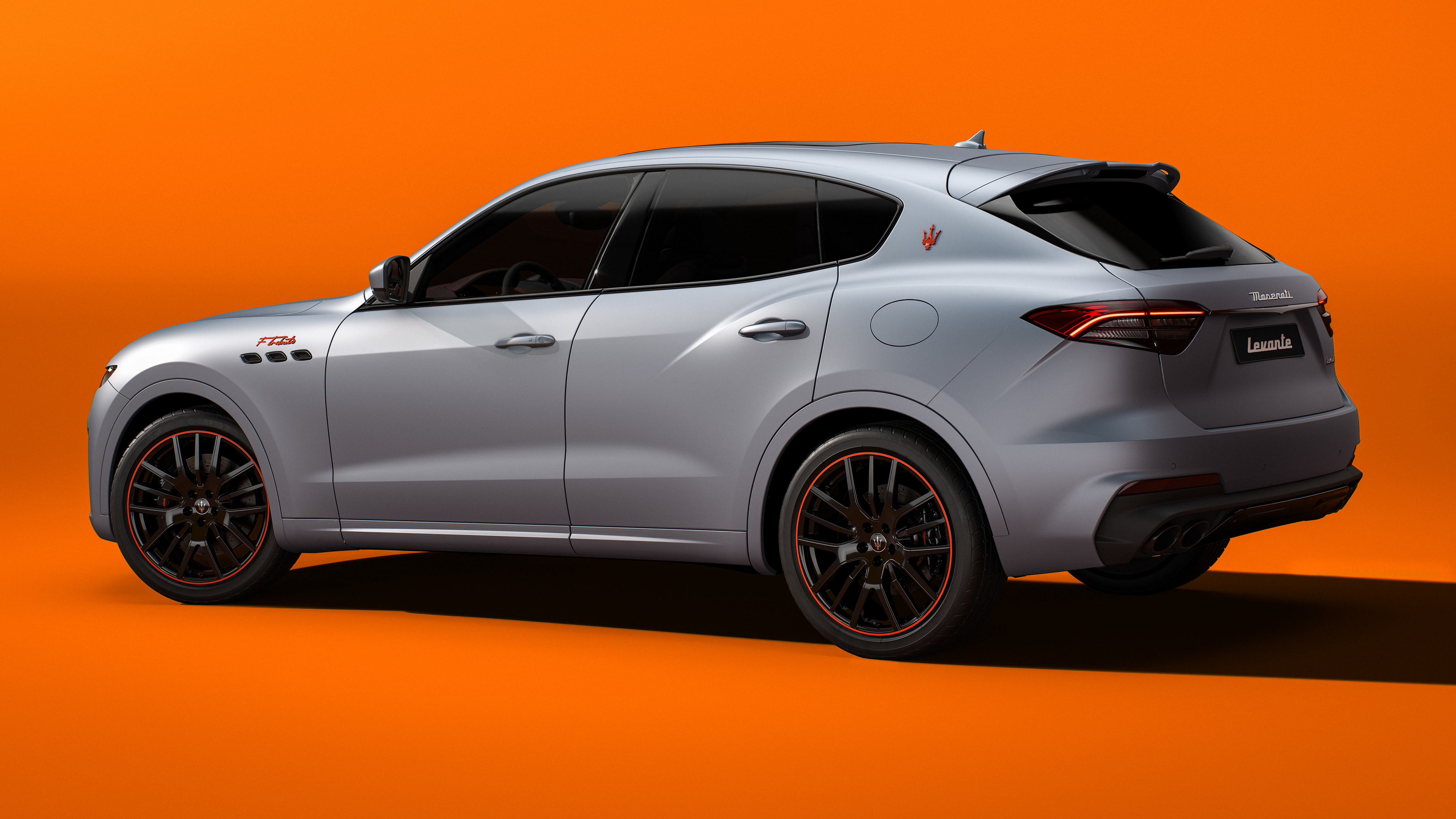 Free photo Maserati Levante Ftributo in matte gray on orange background