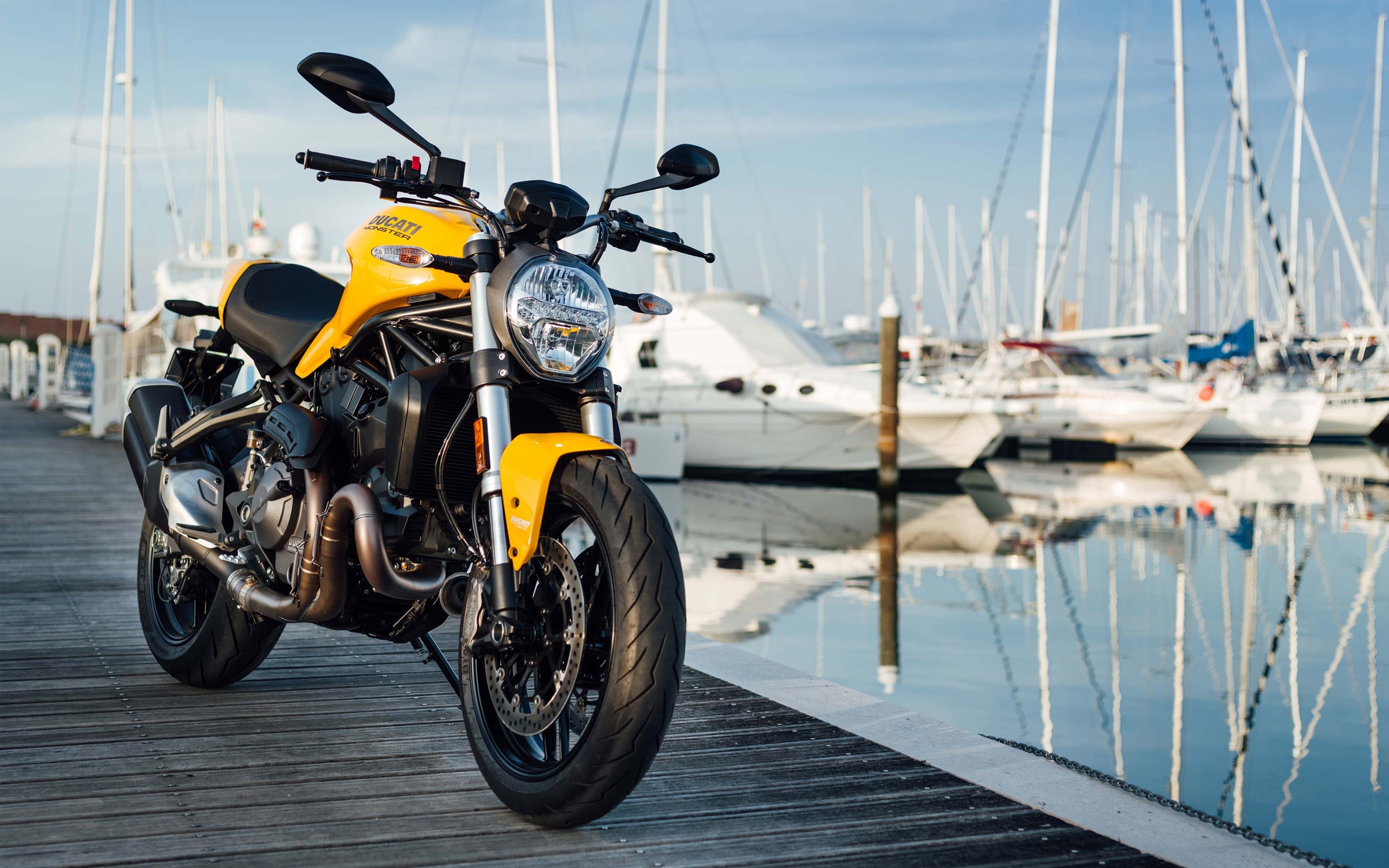 Бесплатное фото Ducati monster 821 в желтом цвете стоит на мостике у воды