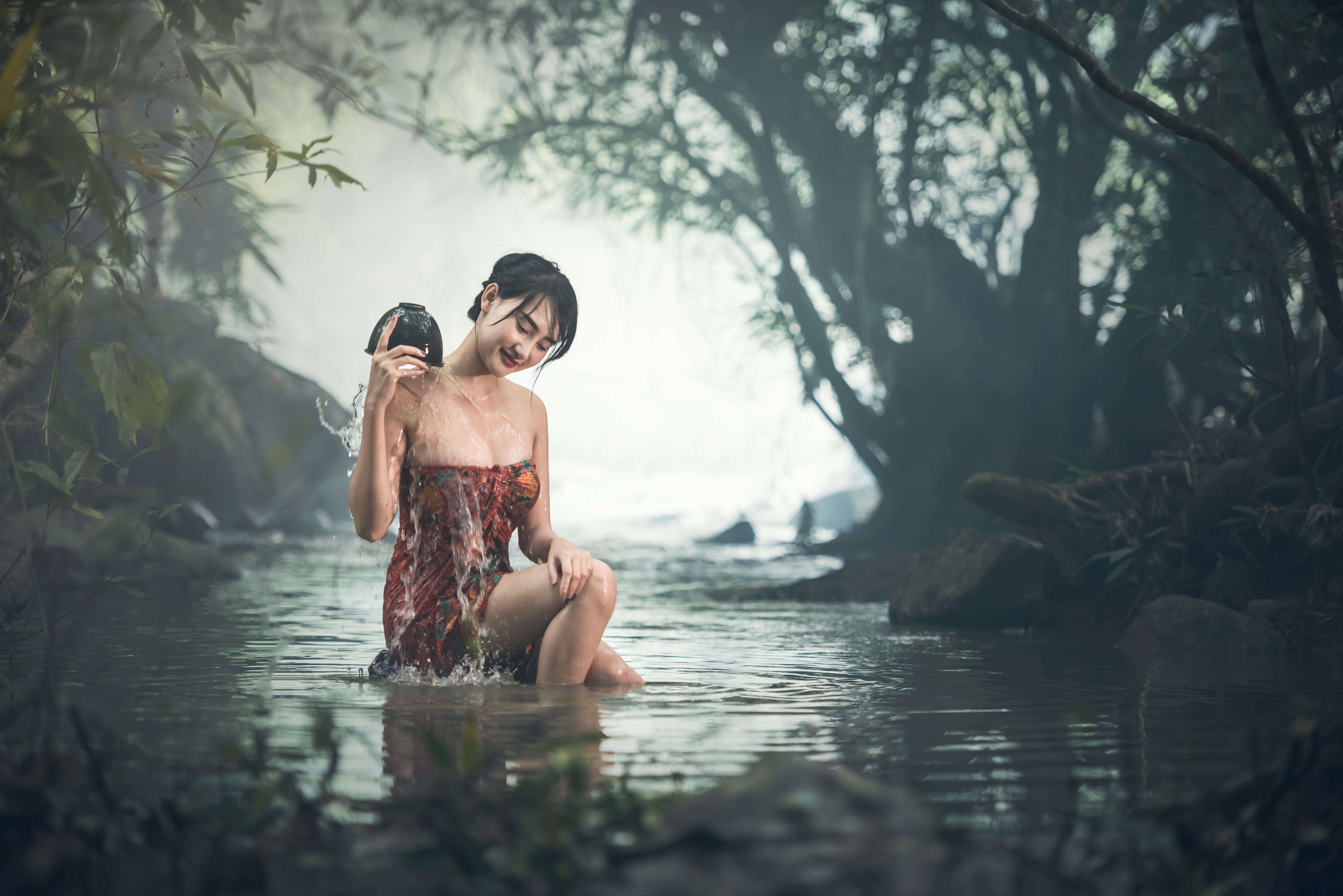 Free photo An Asian woman washes in the river