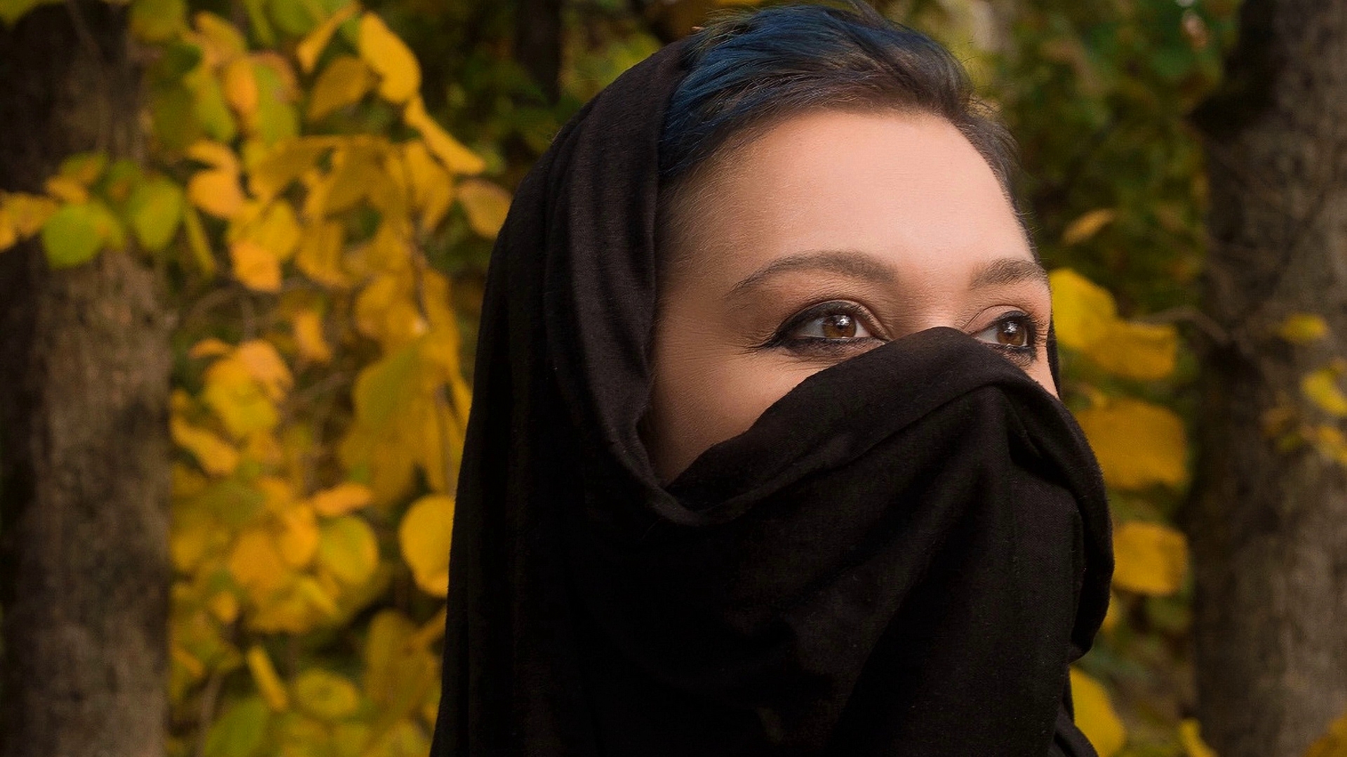 Free photo Model Adele Adamova wearing a scarf against the background of trees